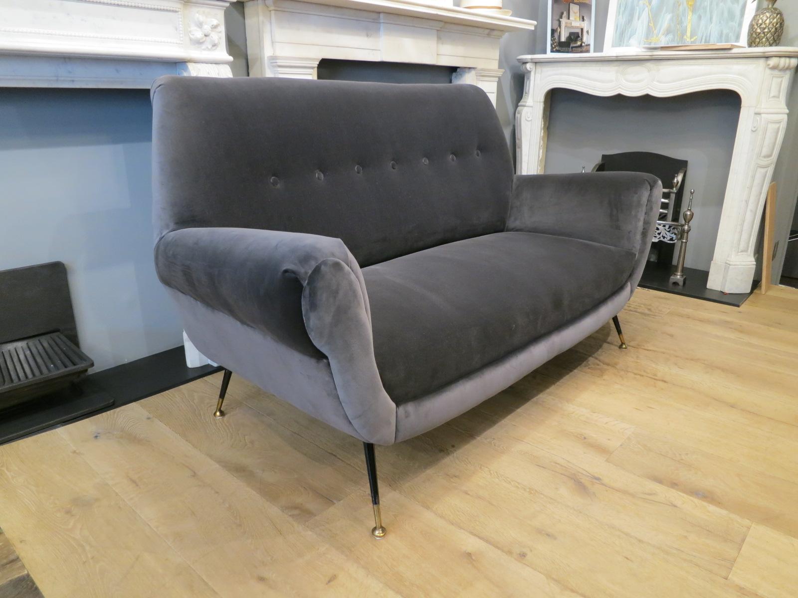A two-seat Italian midcentury sofa in steel blue velvet, by Gigi Radice for Minotti.