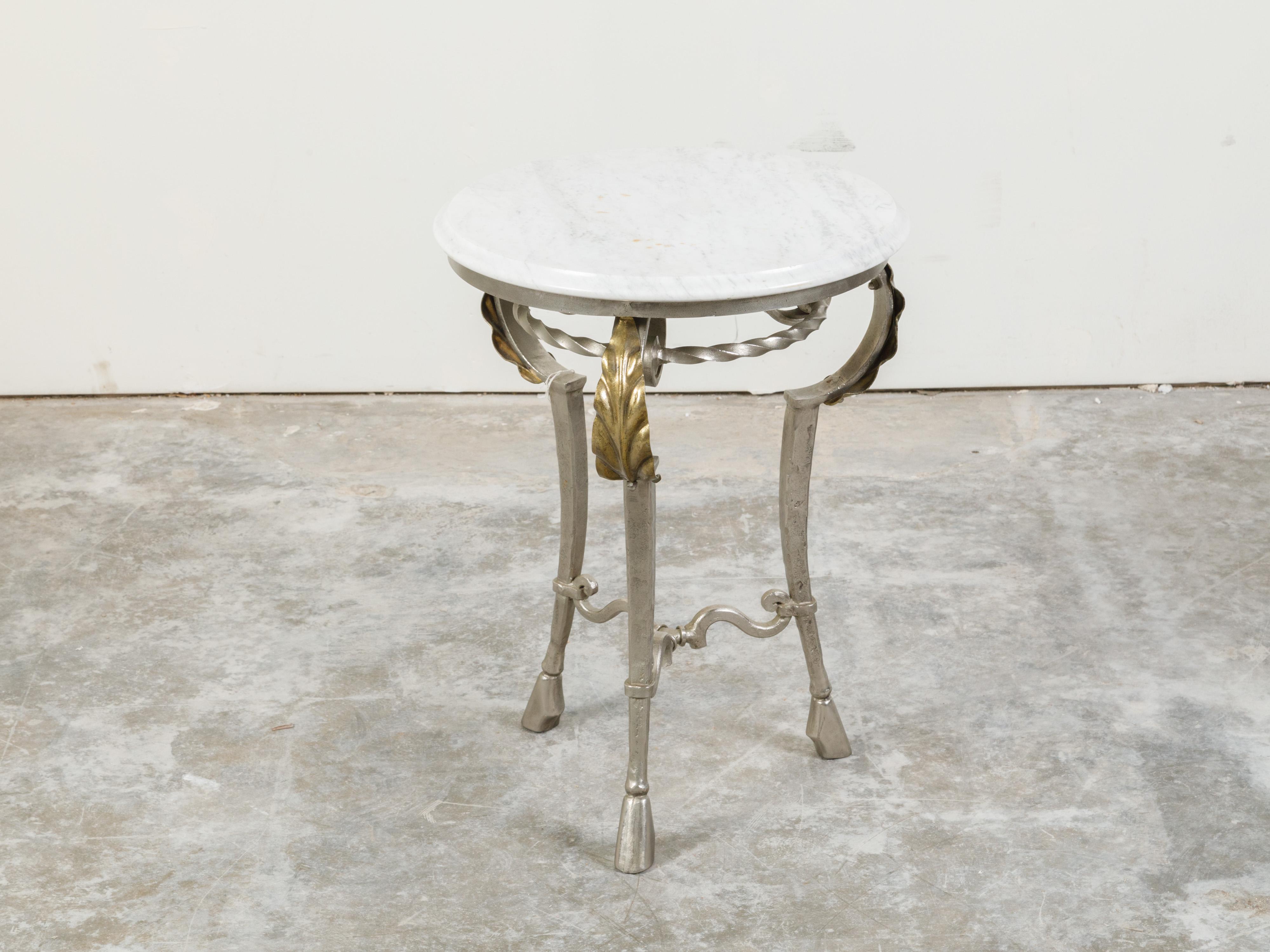 An Italian steel side table from the mid 20th century, with white veined marble top, acanthus leaves and hoofed feet. Created in Italy during the midcentury period, this side table features a circular marble top sitting above a twisted ring