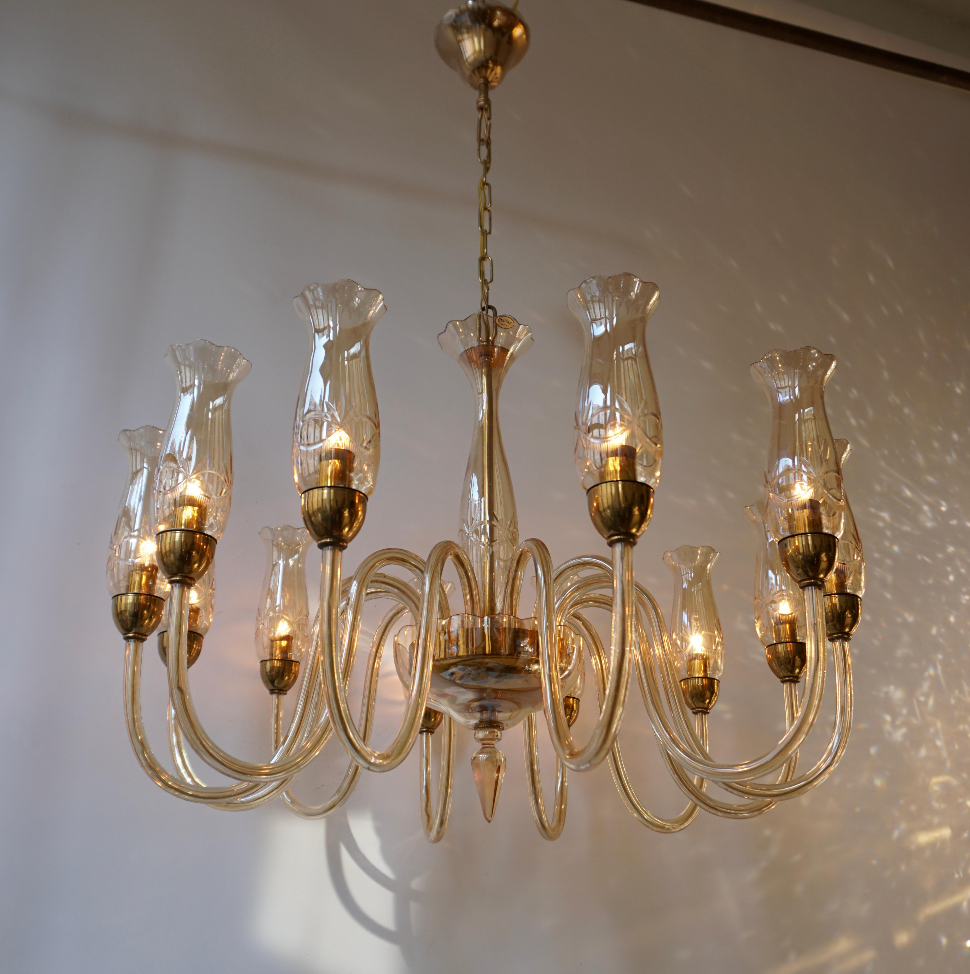 Contemporary Italian midcentury style, clear hand blown Venetian crystal glass chandeliers or pendant in the modern neoclassical style with twelve arms attributed to Barovier with brass trim. Beautiful and fully working chandelier with twelve-light