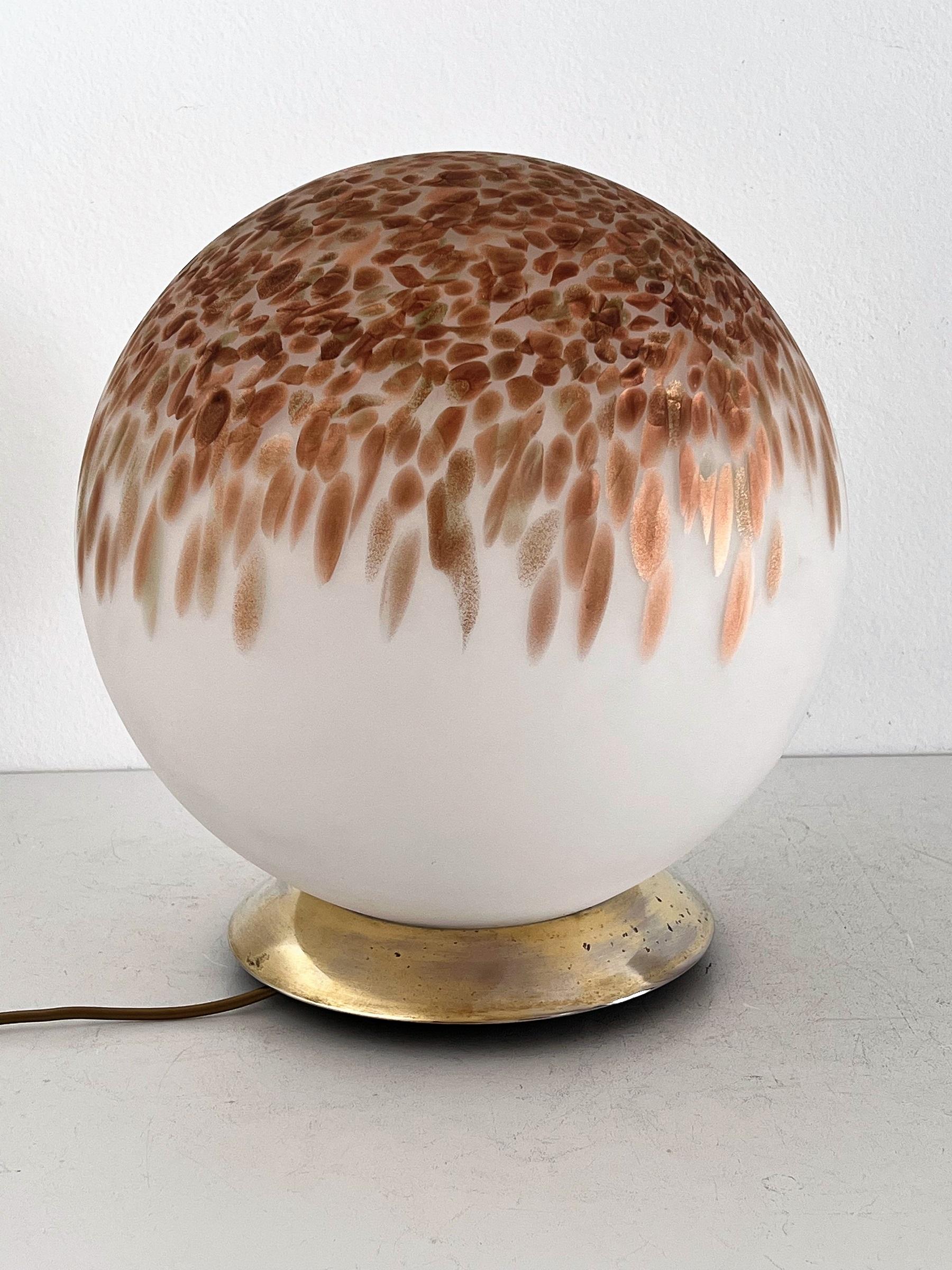 Gorgeous large size Murano glass table lamp Made in Italy in the 1970s. ca.
The table lamps glass ball is made of frosted Murano glass and copper-coloured murrine melted into the glass.
The lamp is beautiful to look at when switched off, but