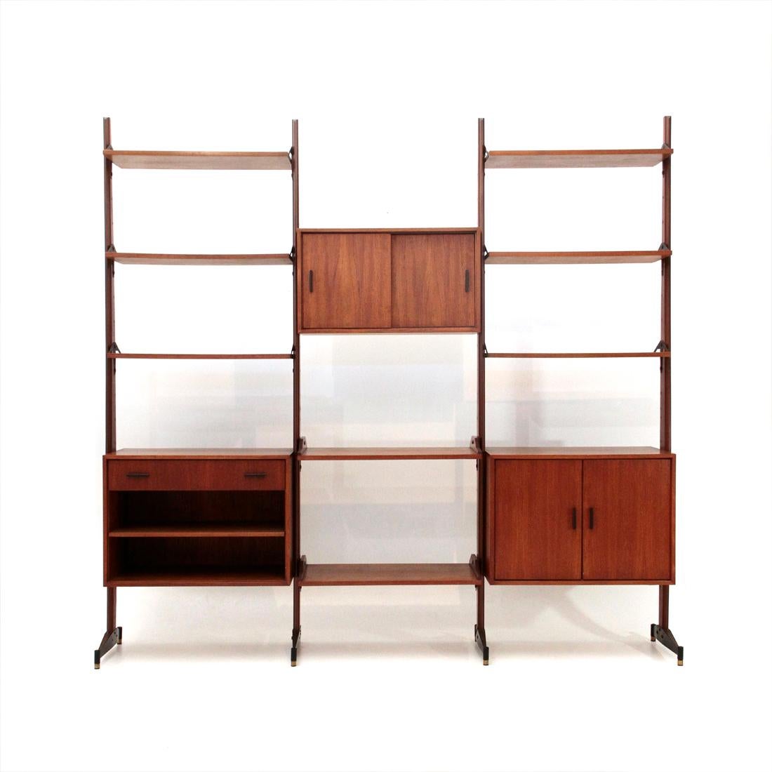 Italian manufacture bookshop produced in the 1960s.
Uprights in teak and black painted metal, height adjustable brass feet.
Containers in teak veneered wood and handles in black painted metal, internal shelves.
Shelves in teak veneered wood and