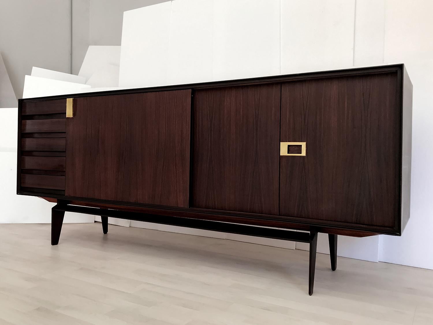 This stylish sideboard has been crafted with a gorgeous material like as teakwood, and it’s finished with brass details.
The internal cabinet is provided with shelves offering plenty of room for storage, hidden in the middle from a sliding door and