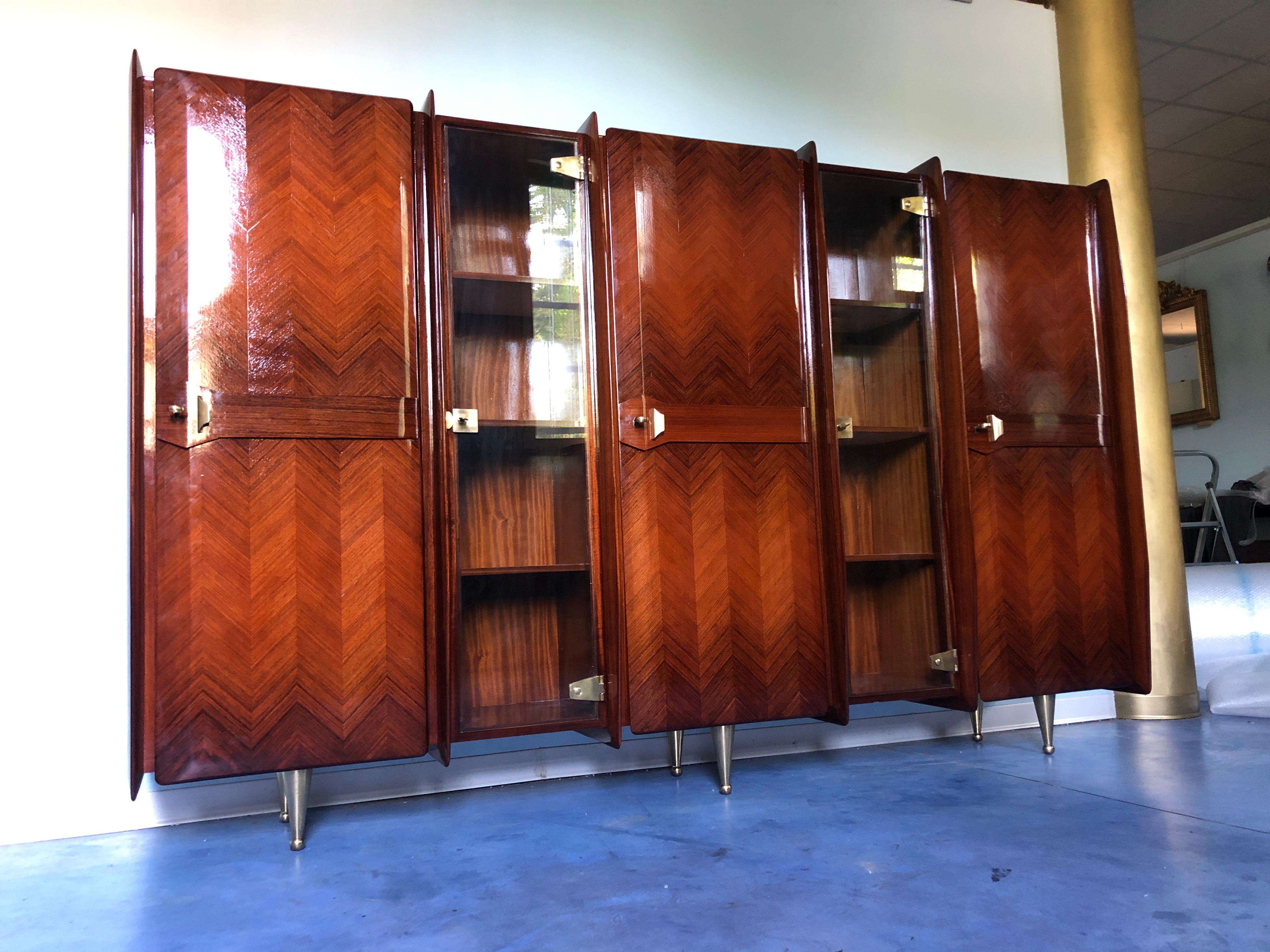 This wonderful Italian sideboard, bookcase, or vitrine has been manufactured by Vittorio Dassi, 1950 and it is a splendid example of the Italian design of the period. 
Stunning teakwood doors texture divided by two locking glazed sections with