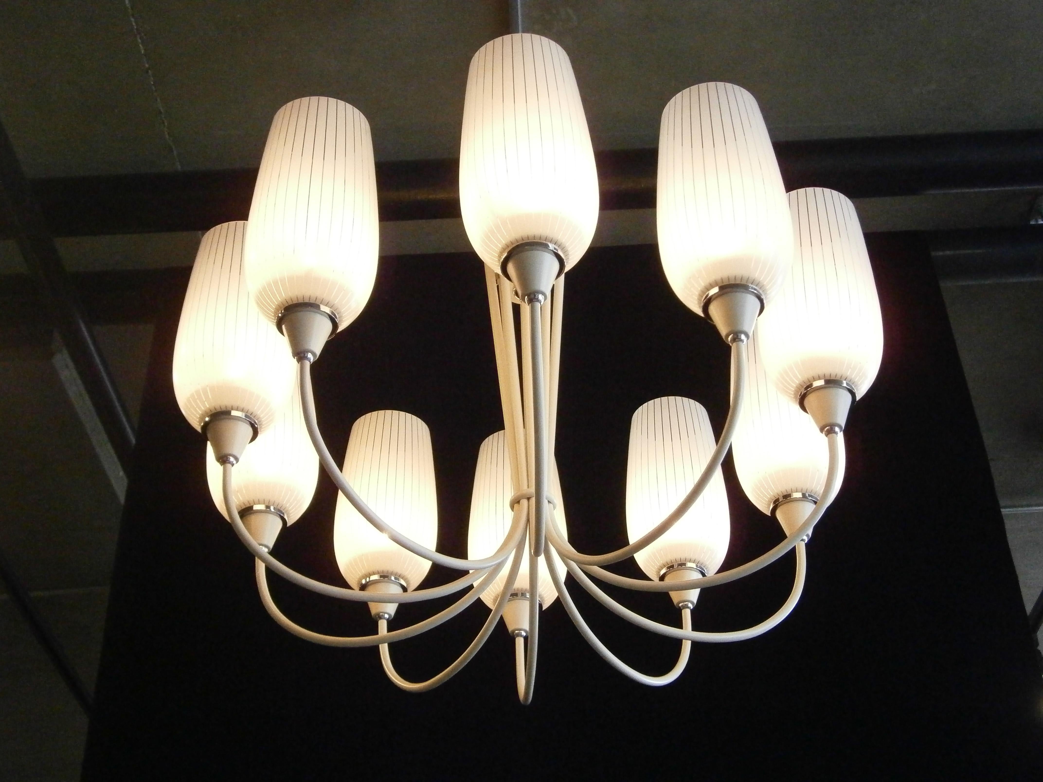 An elegant Italian midcentury painted and nickel-plated ten-arm chandelier with original Murano glass shades. The body and arms are painted a creamy white and the metal accents are finished in a polished nickel plate. The striped Murano glass shades