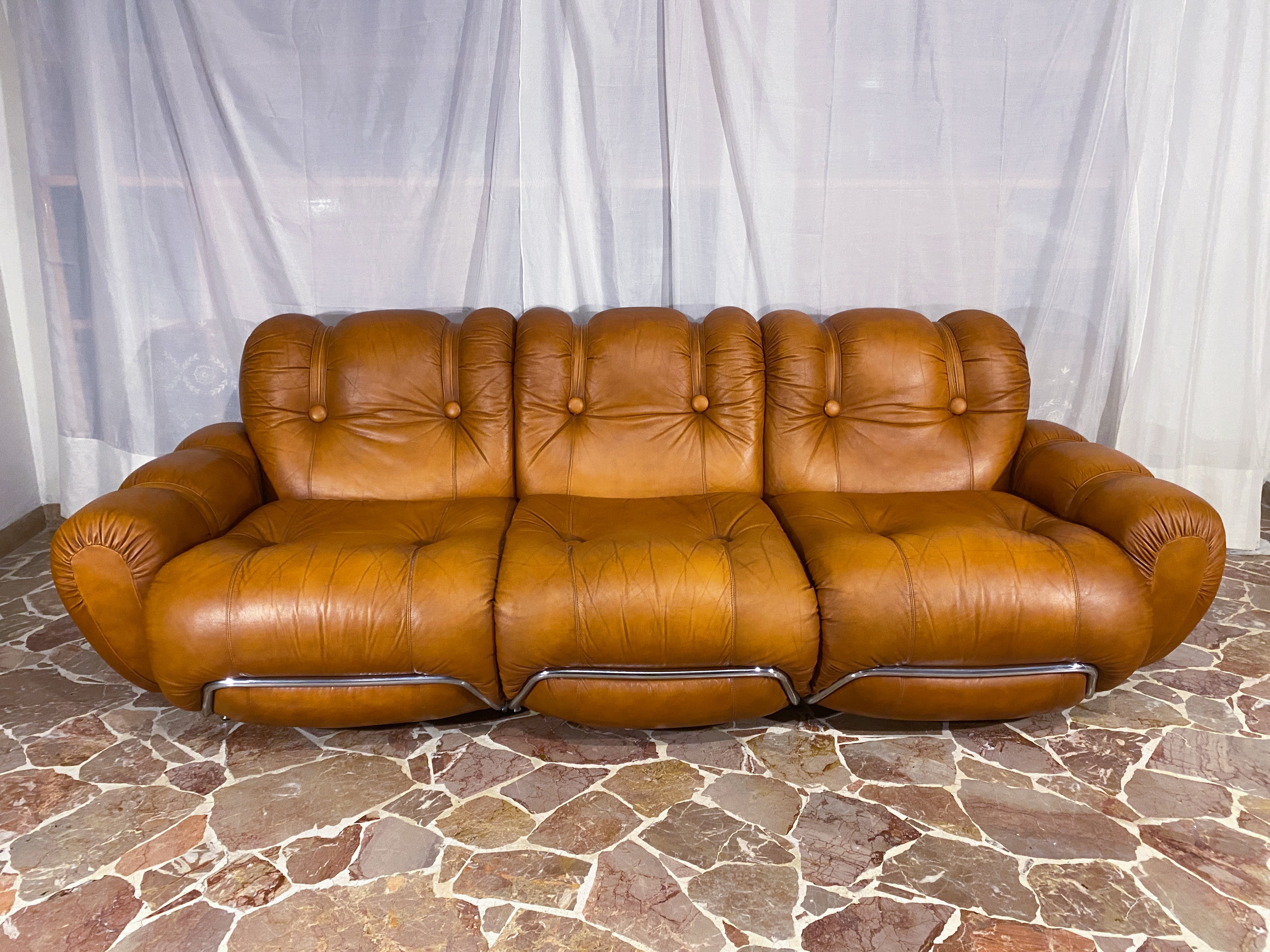 Splendid three-seater sofa made in Italy in the 70s. The seat is very comfortable and supportive. The pads are still original and in very good condition. Original natural leather upholstery in very good condition from the period,a skilled craftsman