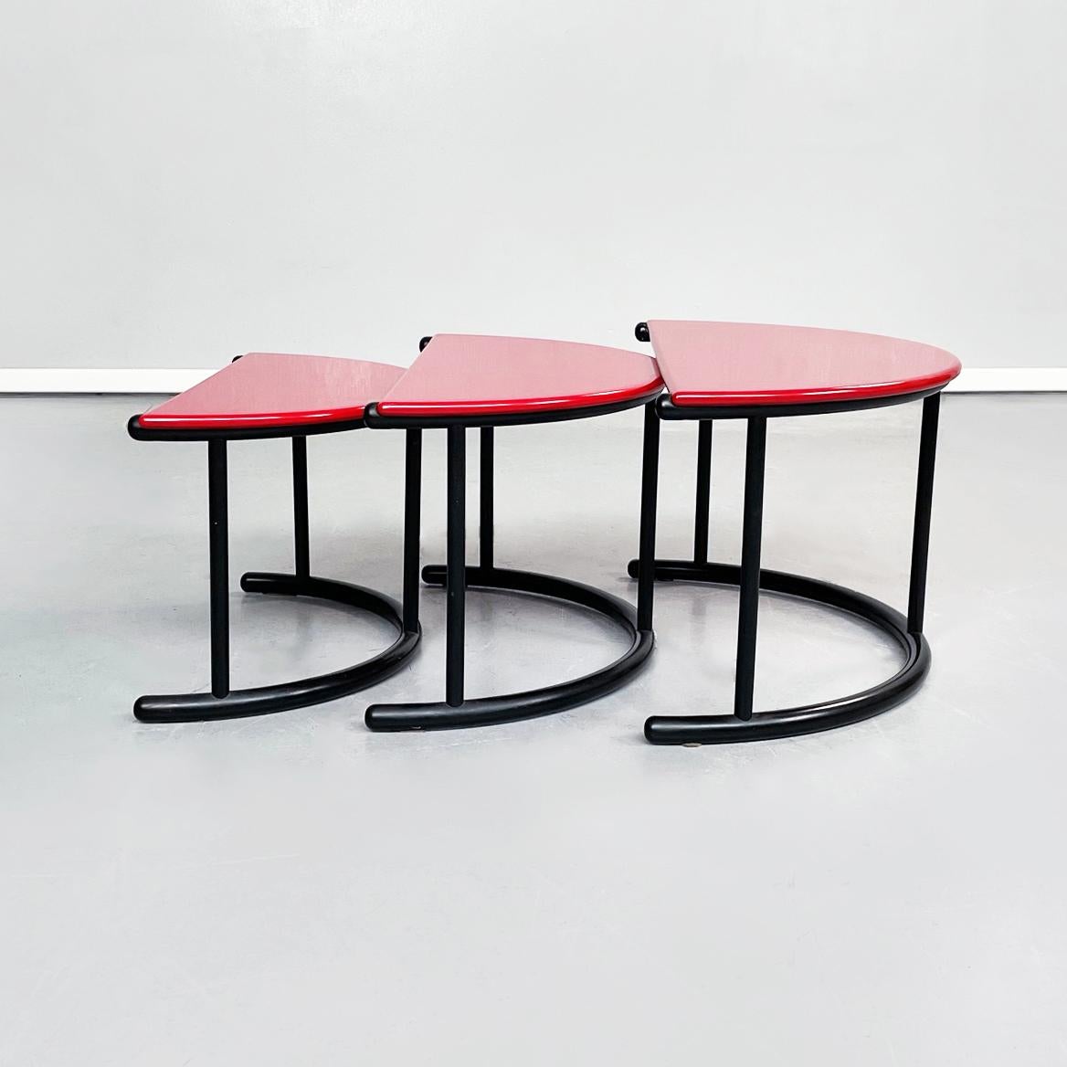 Italian mid-century Trio of coffee tables Tria by Frattini Morphos Acerbis, 1980s.
Trio of coffee tables Tria in the shape of a semicircle. The red lacquered wooden top is supported by a black painted wooden tubular structure.
Produced by Morphos