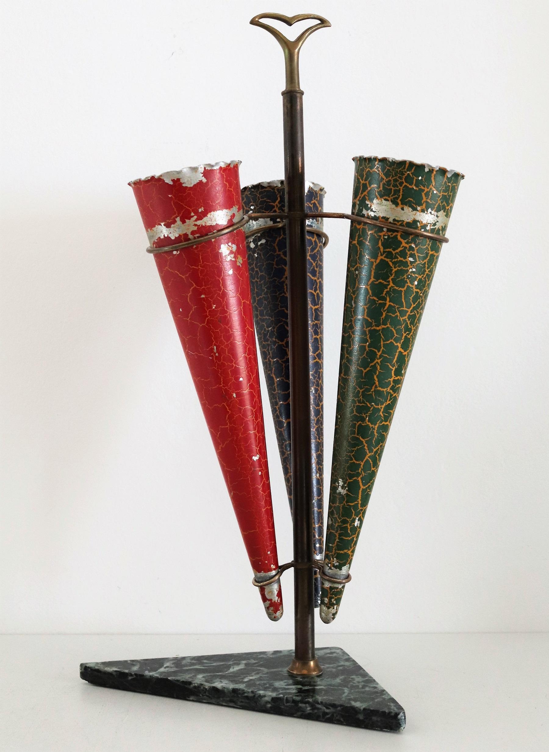 Stunning umbrella stand made in Italy in the 1950s.
The strong brass holder, which got deep dark patina from the time, is fixed on a green alps marble base.
Three movable aluminum bags in red, blue and green are inserted in the brass