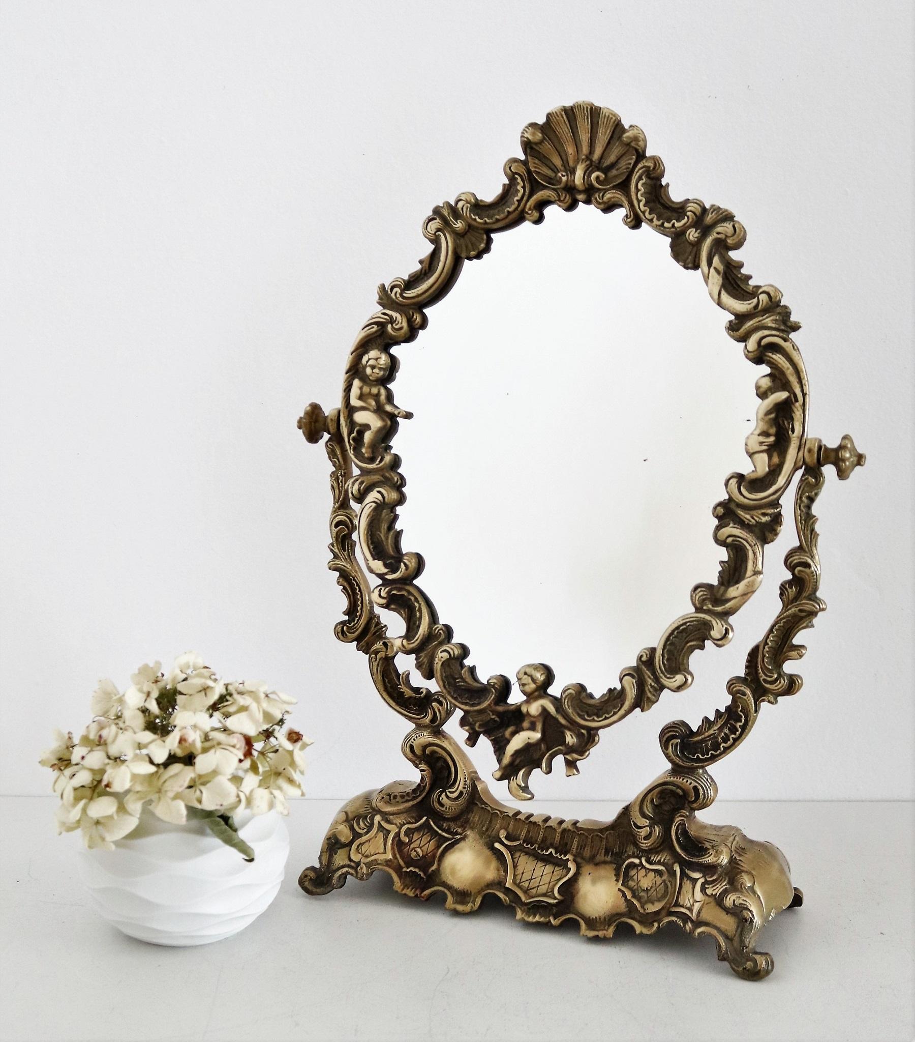 Magnifique miroir de coiffeuse en bronze lourd et plein, avec des anges (putti) et des coquillages dans le cadre.
Fabriqué en Italie au milieu du siècle dernier.
Le verre du miroir encadré est fixé à la base par deux vis, et peut être tourné dans