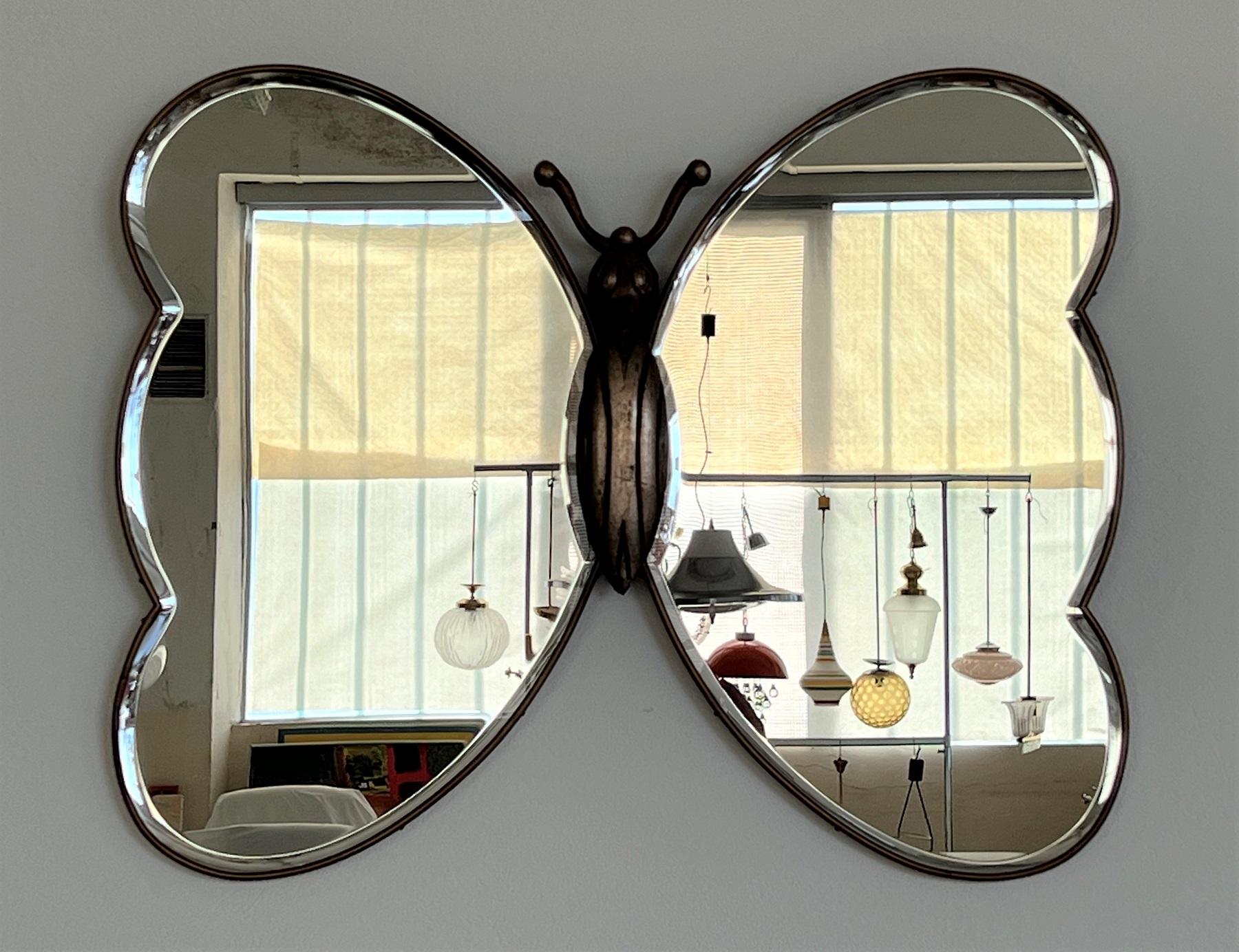 Gorgeous large wall mirror in the shape of a butterfly with brass frame.
Made in Italy around the 1960s.
The mirror consists of two wings with brass frame and a middle part made of wood.
Both wing parts each have a beautiful mirror glass made of cut