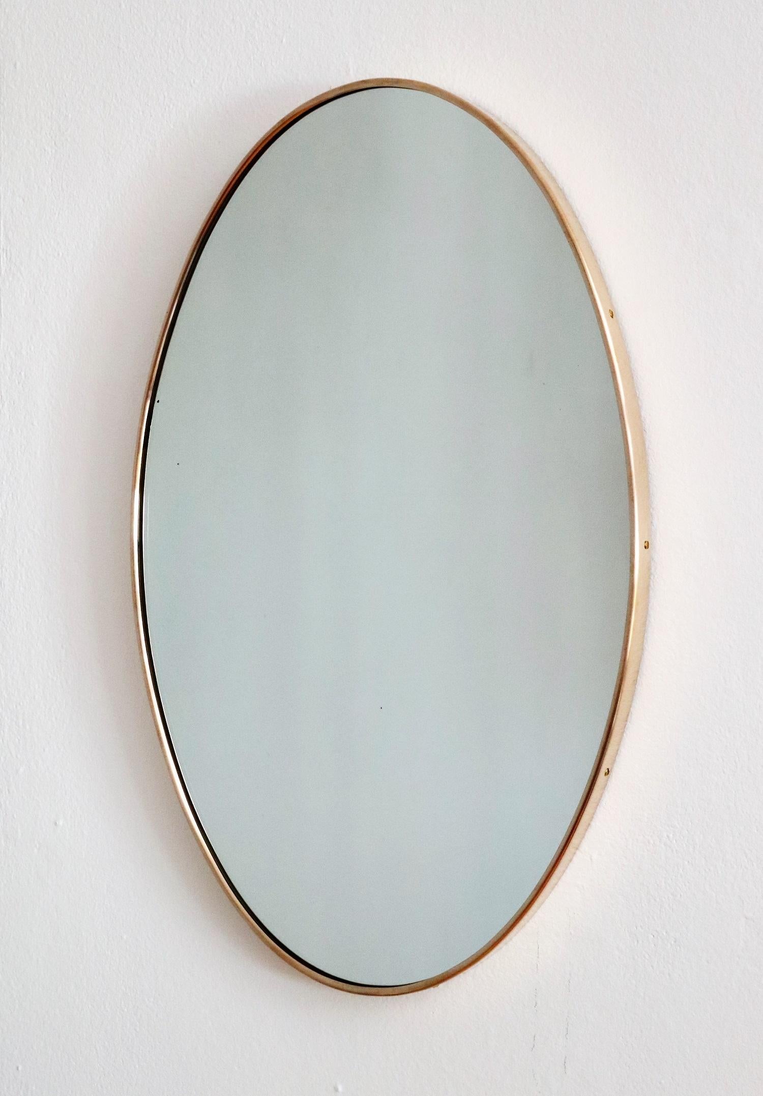 Beautiful and heavy oval wall mirror with thick brass frame from Italian production of the 1970s.
The crystal glass is in original condition with very few spots on the glass, no defects or chips on the glass.
The mirror is equipped with strong