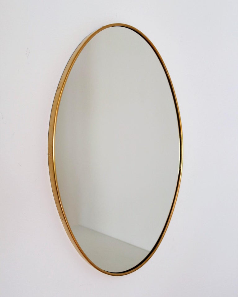 Beautiful and heavy oval wall mirror with brass frame from Italian production of the 1950s.
The crystal glass have been renewed.
The mirror is equipped with strong wooden back plate and hook for wall hanging.
The brass frame have been polished