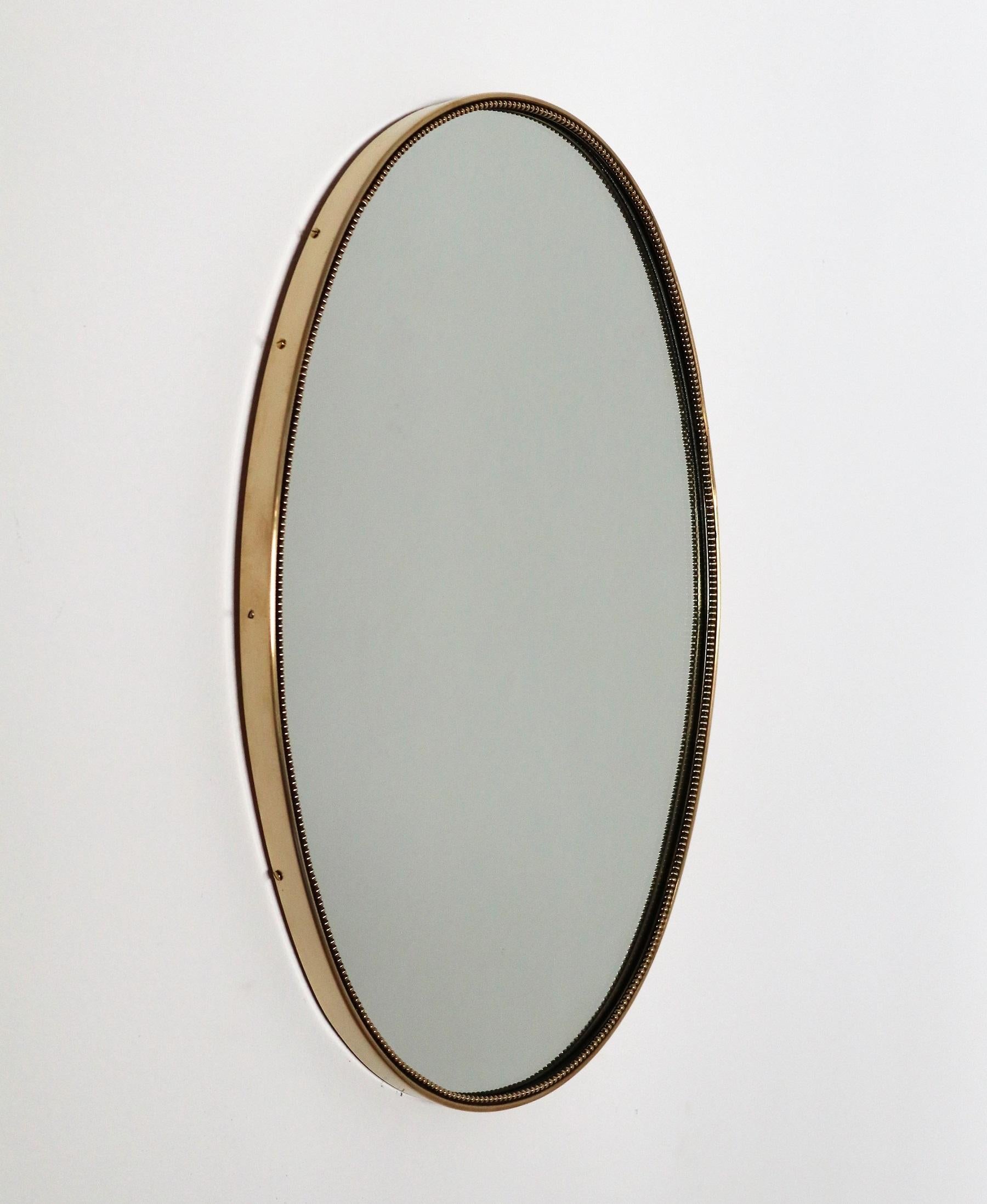 Beautiful and heavy oval wall mirror with brass frame with decors from Italian production of the 1960s.
The crystal glass is in original condition, no defects or chips on the glass.
The mirror is equipped with strong wooden back plate and hook for