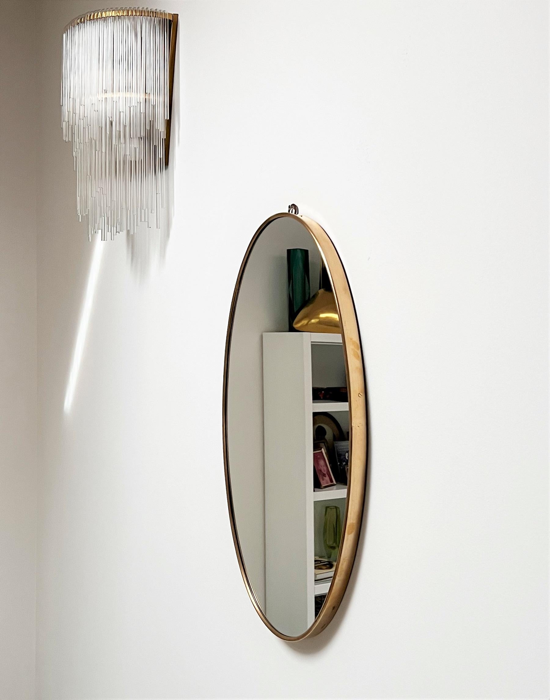 Beautiful and original oval wall mirror with brass frame from Italian production of the 1960s.
The crystal glass was renewed and is in excellent condition. 
The mirror is equipped with strong wooden back plate and hook for wall hanging.
The brass
