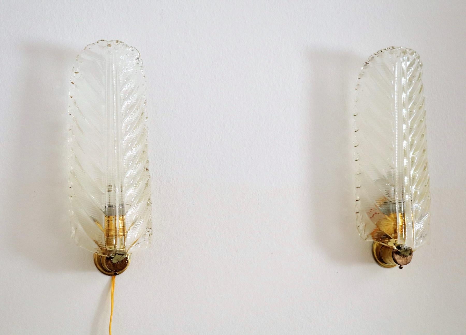 Gorgeous pair of wall sconces in the shape of light amber colored long leaves.
Made in Italy in the 1970s.
The wall device is made of brass.
New wiring. (Please note: the wire on the picture will be hidden during mounting inside the wall