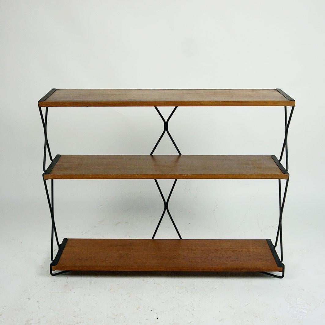 This charming Mid-Century Modern small bookcase or Rack has been designed in 1956 for the Triennale Milano and was manufactured by I.S.A. Bergamo Italy.
It features three boards made of Walnut and a frame of blackened steel. You can still find the