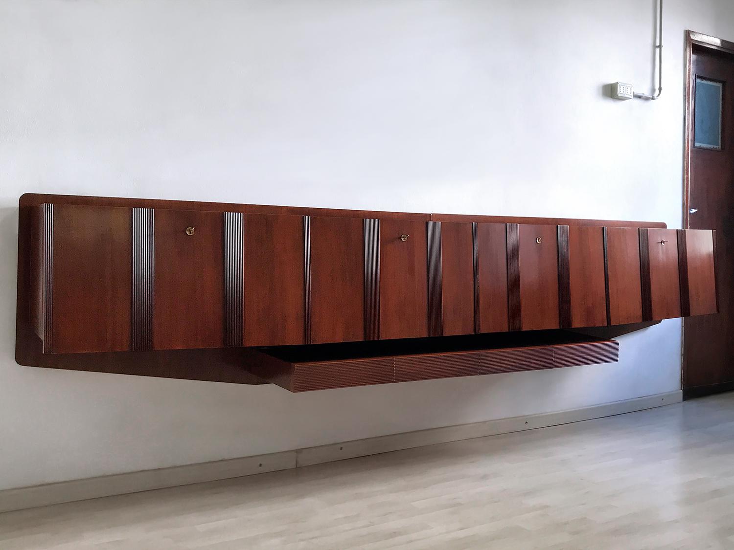 Stunning and very rare Italian wall-mounted Sideboard of the 1950s, a real unique piece well designed in the manner of Paolo Buffa or Vittorio Dassi.
Its uniqueness is given by different factors, first one the impressive dimensions of its walnut