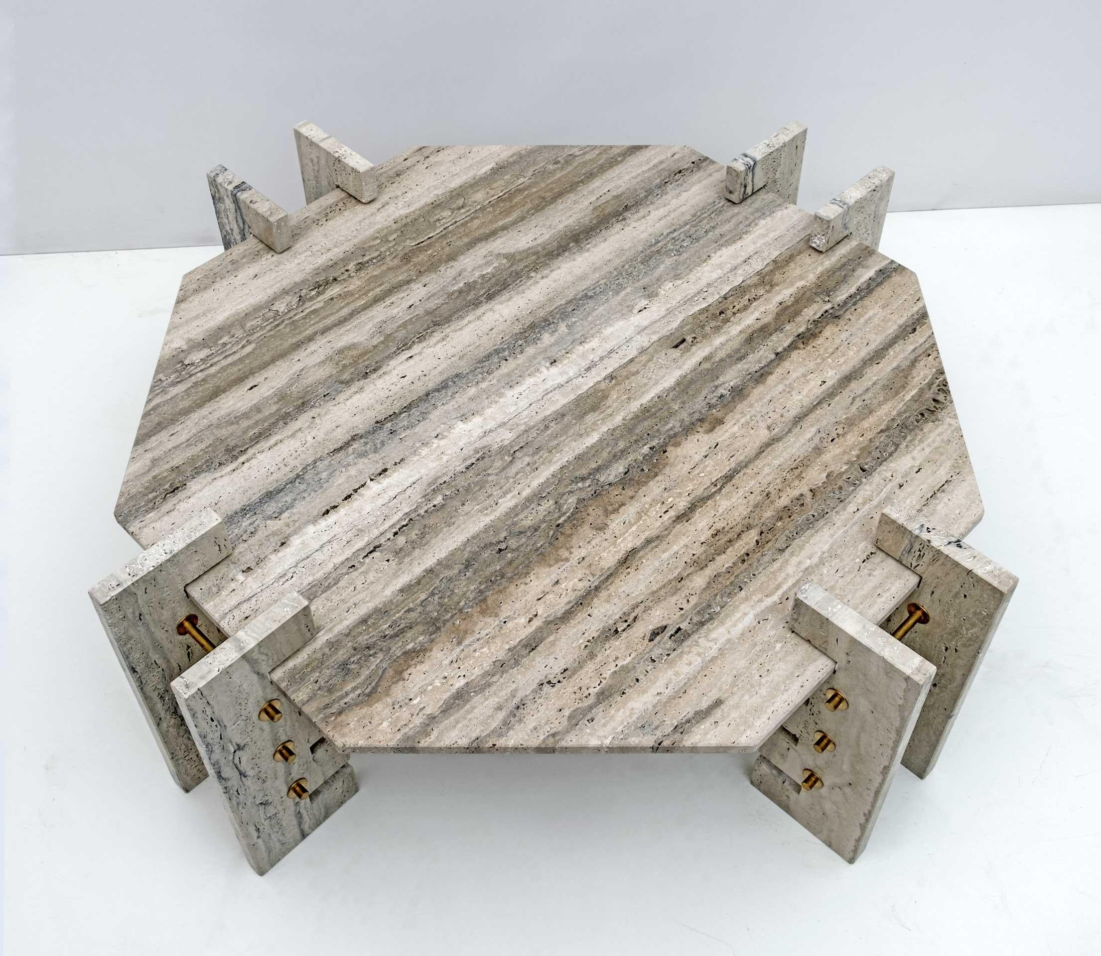Particular octagonal table in Travertine with grooved bases to allow the lowering of the top, the table is mounted with brass bolts, with a minimalist shape, produced in the 70s, in perfect condition, as shown in the photos.