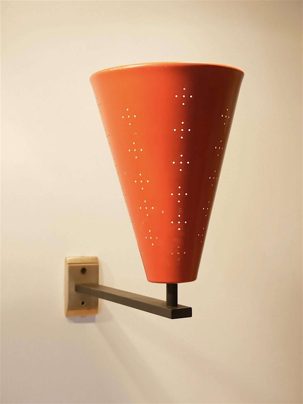Decorative Italian midcentury wall sconce, brass base with black painted arm ending with cone shaped perforated metal in red.