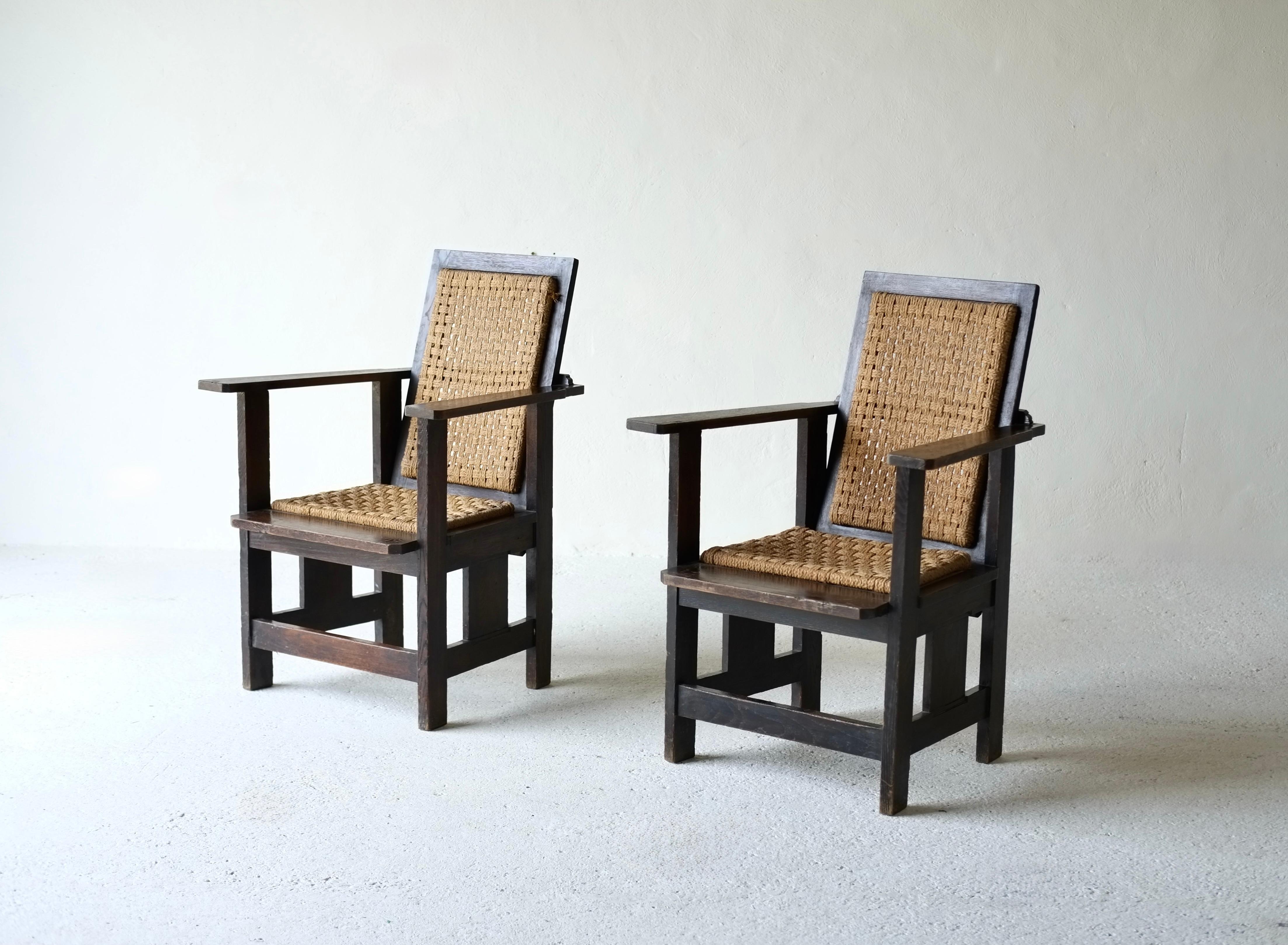 Pareja de sillones minimalistas de principios del siglo XX, de madera y cuerda, a la manera de Gerrit Rietveld. 

Las sillas están en buen estado para su edad, sin roturas en los asientos ni en los respaldos de cuerda. Ligeras marcas en la madera. 