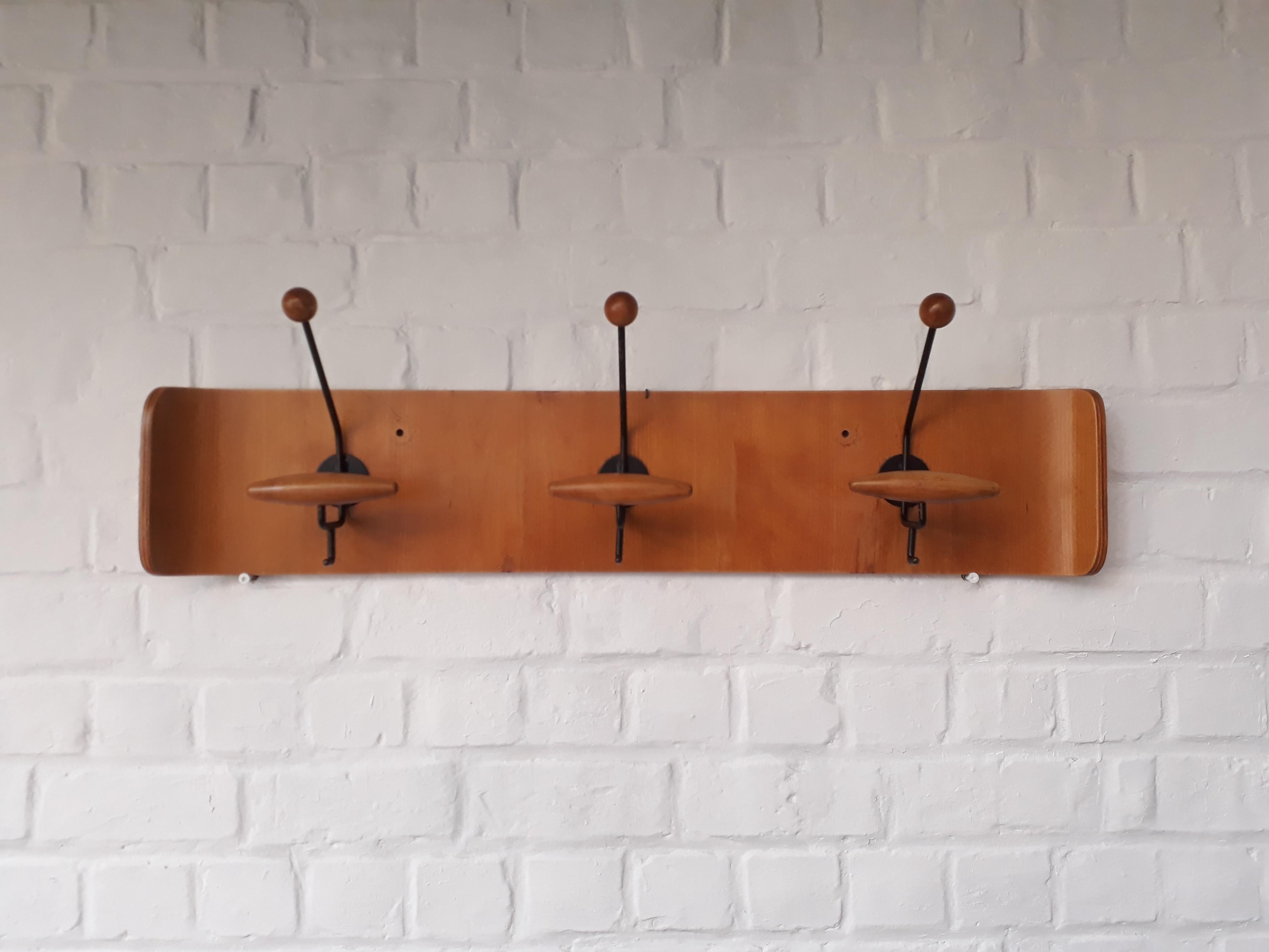 Italian sleek design coatrack with a skateboard shaped plywood back matching black metal painted hanger bases. Each hanger has a 2x wooden elements ornating it a bit more.