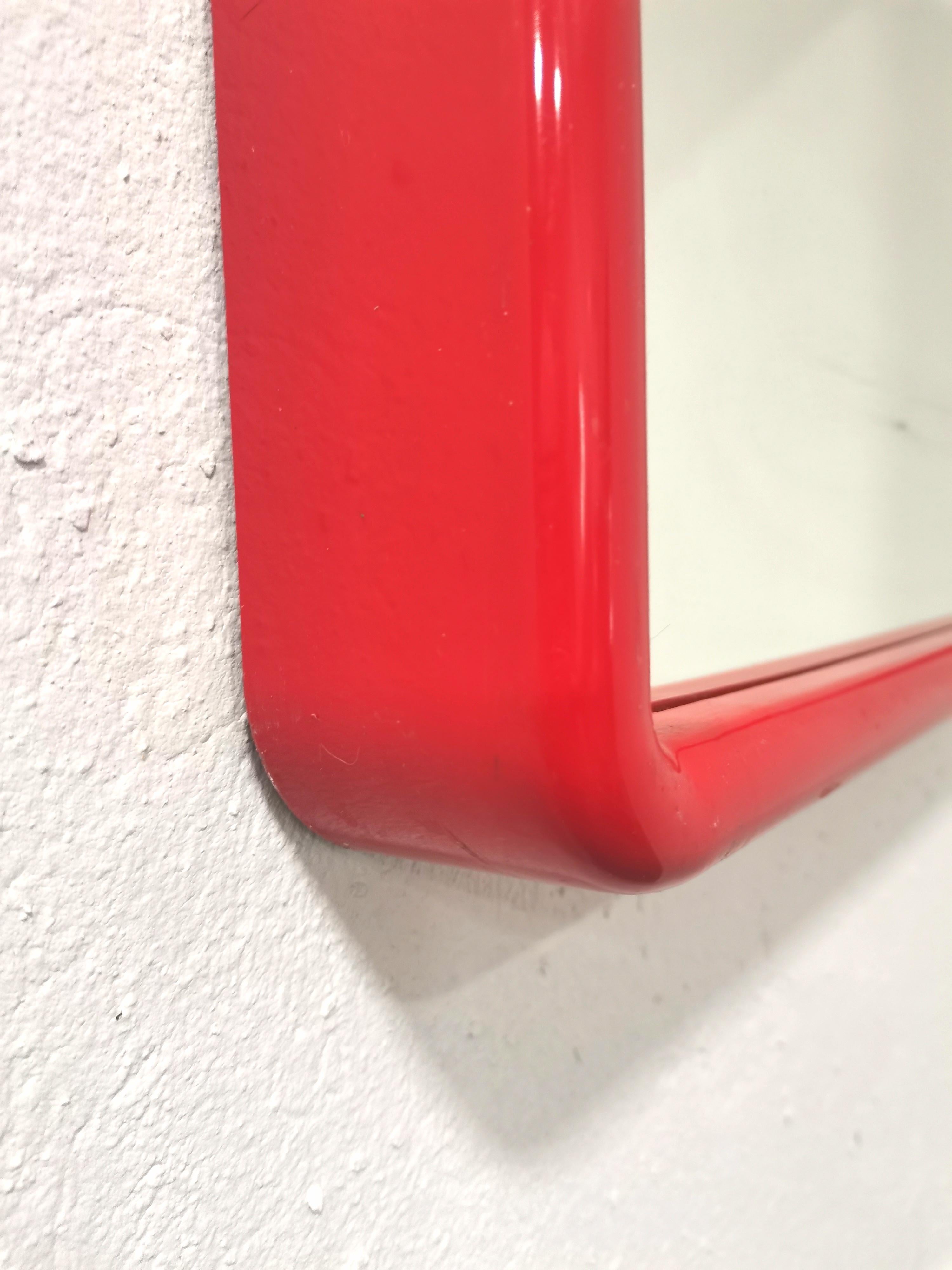 Italienischer Vintage-Spiegel. Hergestellt in den 1970er Jahren. Einfachheit der Form und ewiges Design. Dieser Spiegel wertet mit seiner minimalistischen Ästhetik und seiner leuchtenden roten Farbe jeden Raum auf. 
MATERIAL: Kunststoff,