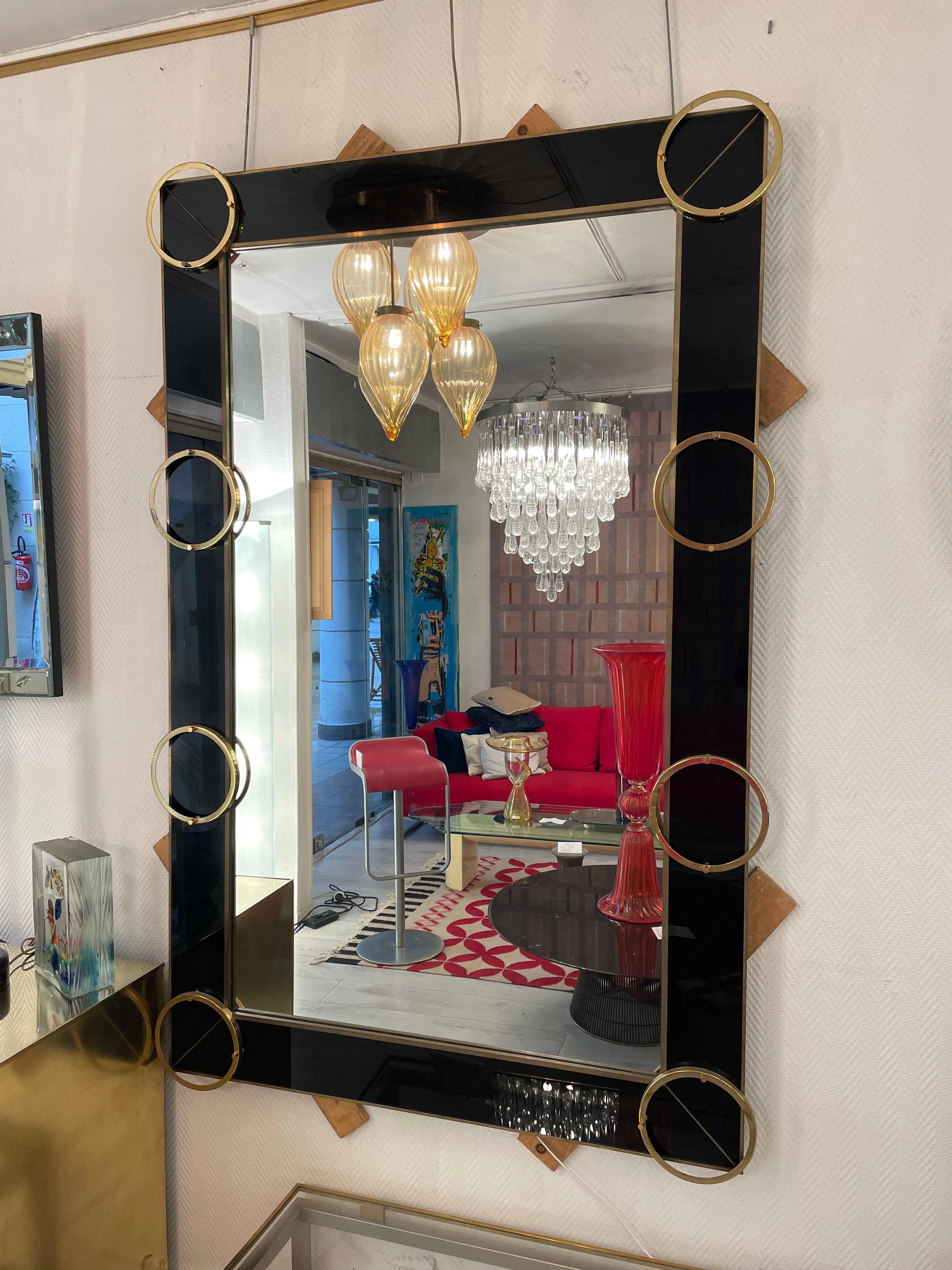 Italian mirror from the 70's in tinted glass and brass .can be installed in both directions .price : 4500 euros 

Length: 182 cm x W: 116.5 x D: 6 (with 1cm decorative rings)