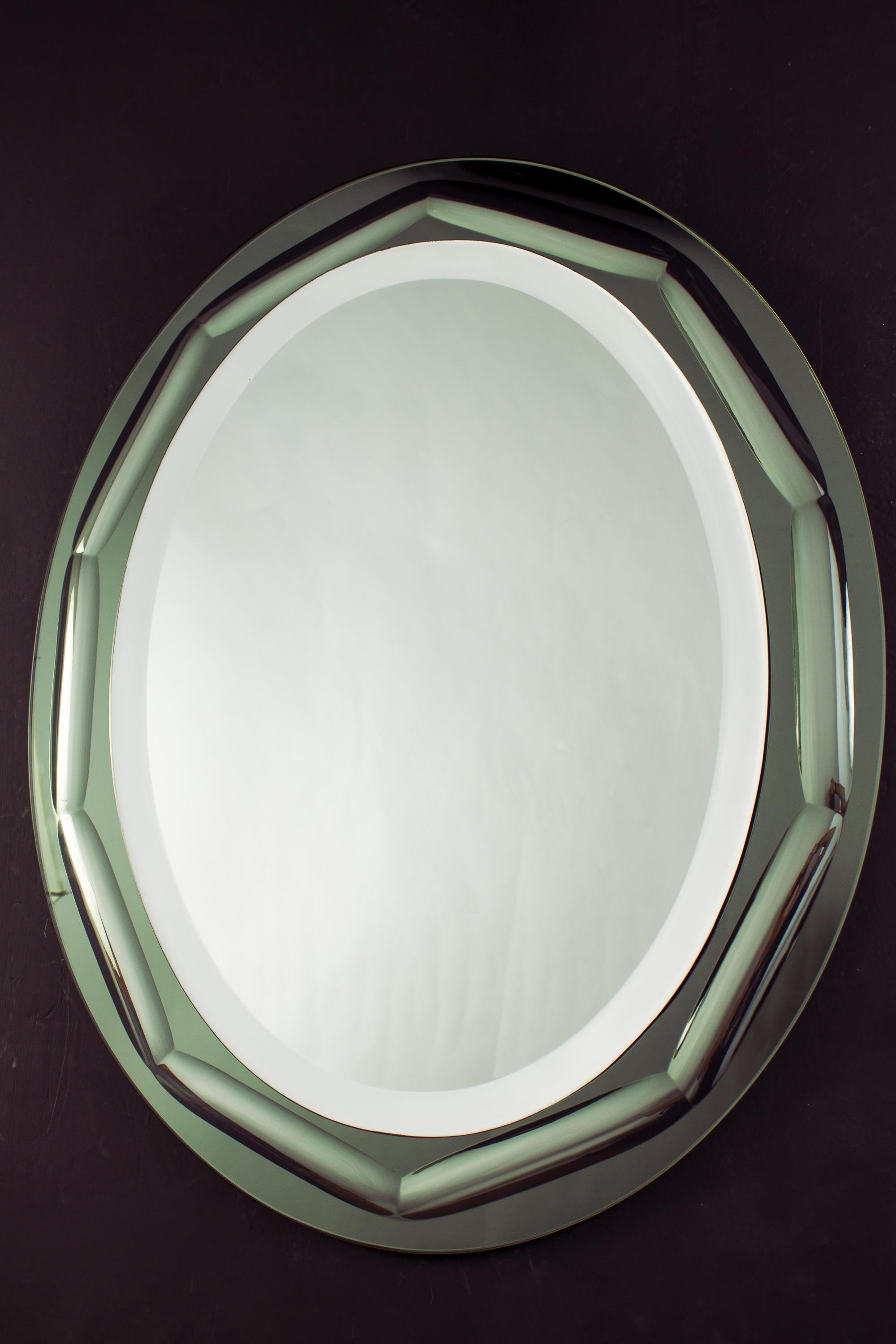 Italian oval shaped mirror in the style of Fontana Arte. The mirror is in green colored glass.