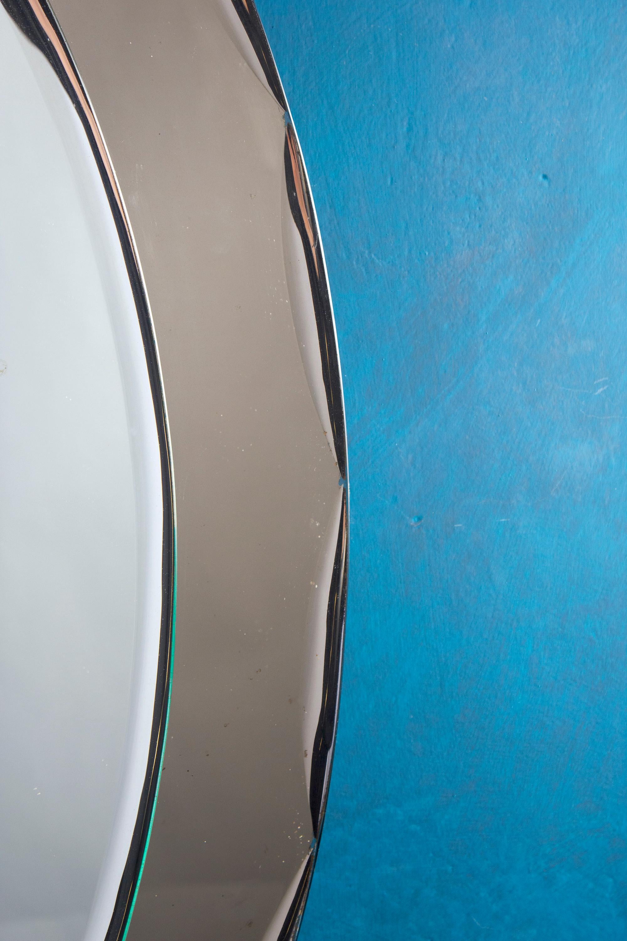Italienischer Spiegel in ovaler Form im Stil von Fontana Arte. Der Spiegel ist aus bronzefarbenem Glas.
 Sehr guter Vintage-Zustand, nur der Verschleiß der Zeit.