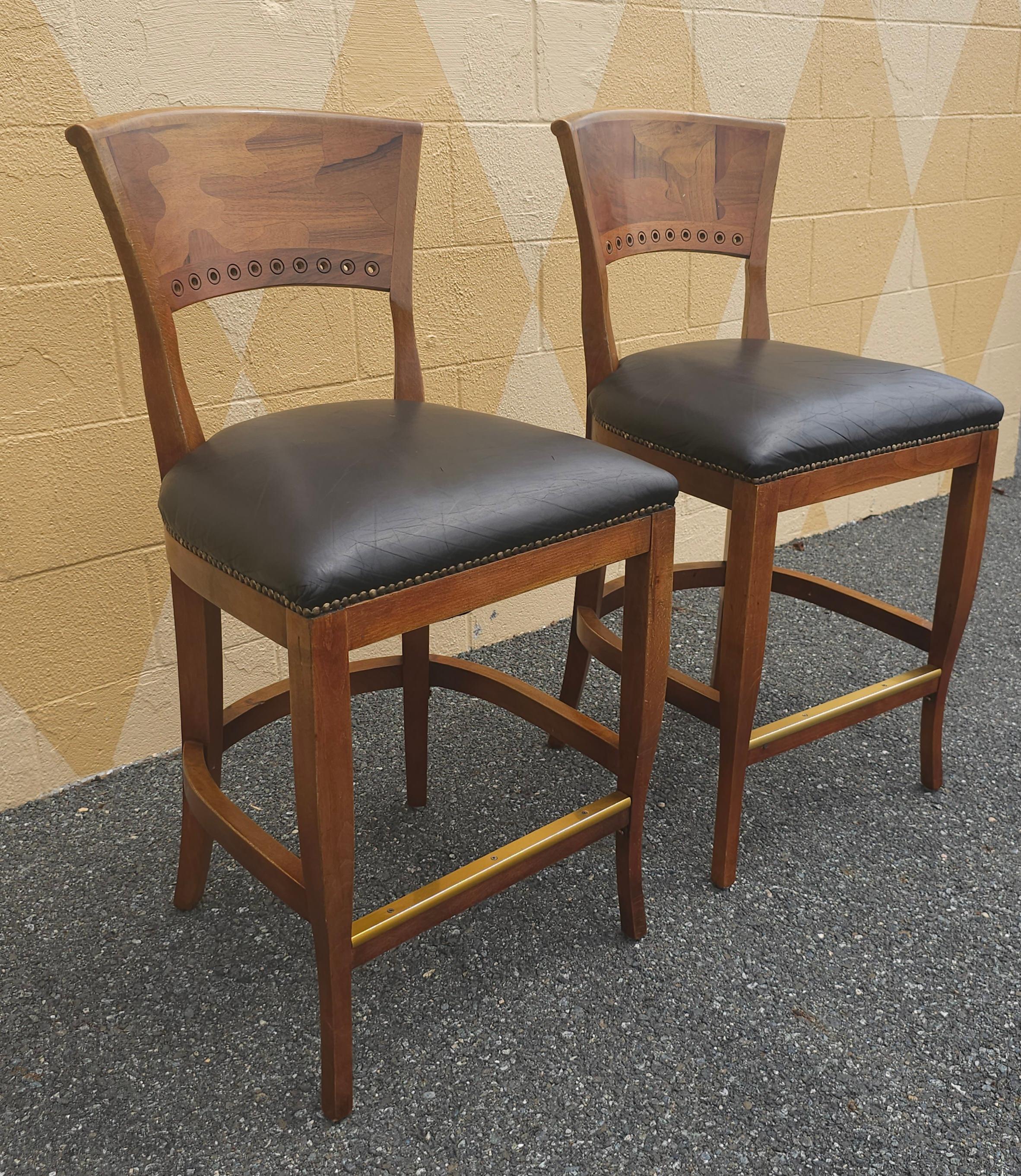 A pair of Italian Mixed Fruitwoods and quality Top Grain Leather Upholstered seat with Brass NailHeads trims and brass foot rest counter Stools. Sleek back rest with assorted mixed fruitwoods
Measures 19.5