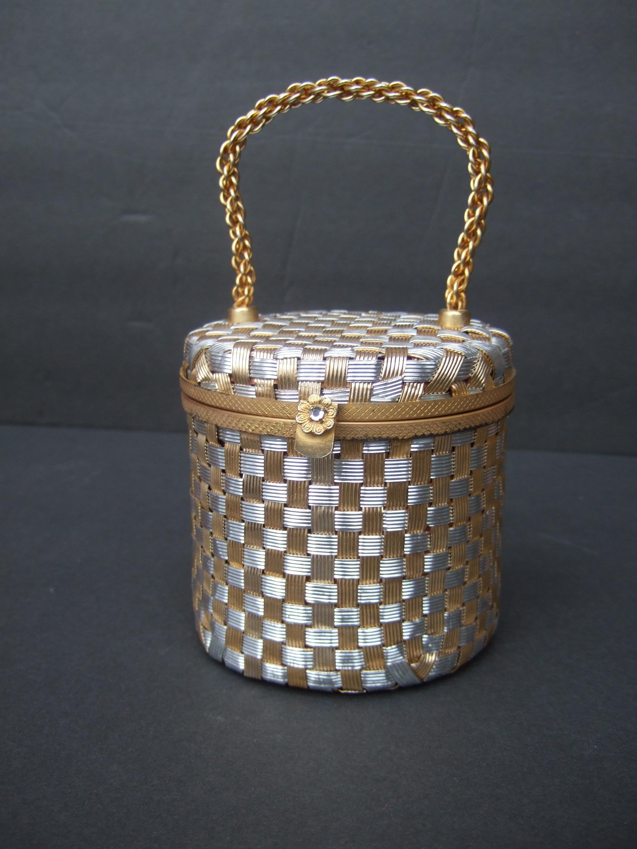 Italian mixed metal basket weave diminutive evening bag designed by Walborg c 1960s
The charming small size cylinder shaped handbag is designed with woven bands of silver
and gold tone metals in a basket weave pattern

Carried with a stationary