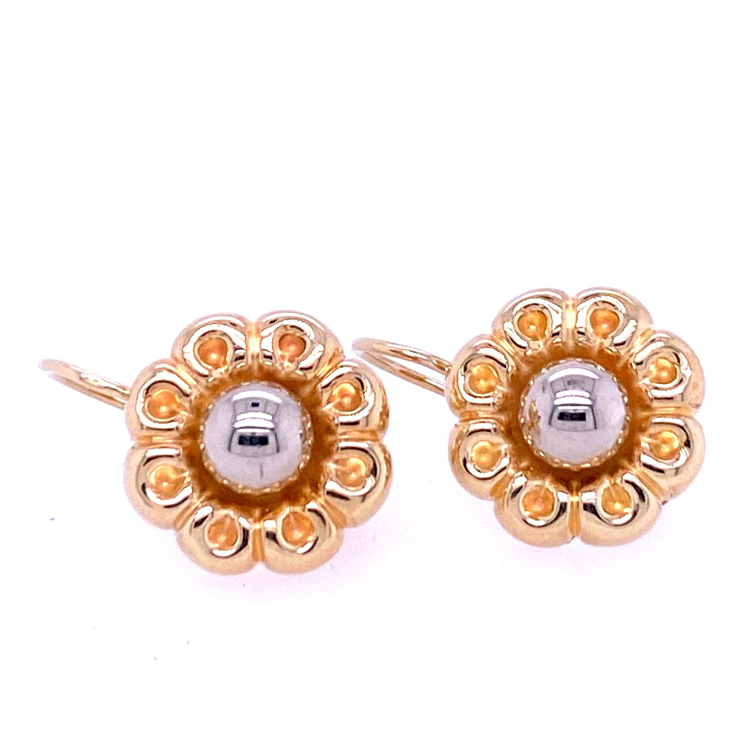 One pair of mixed metal flower earrings made in Italy, each feature a 14 karat white gold ball center surrounded by 14 karat yellow gold petals. The earrings measure 14.75mm in diameter and have leaverbacks.  Circa 1980s