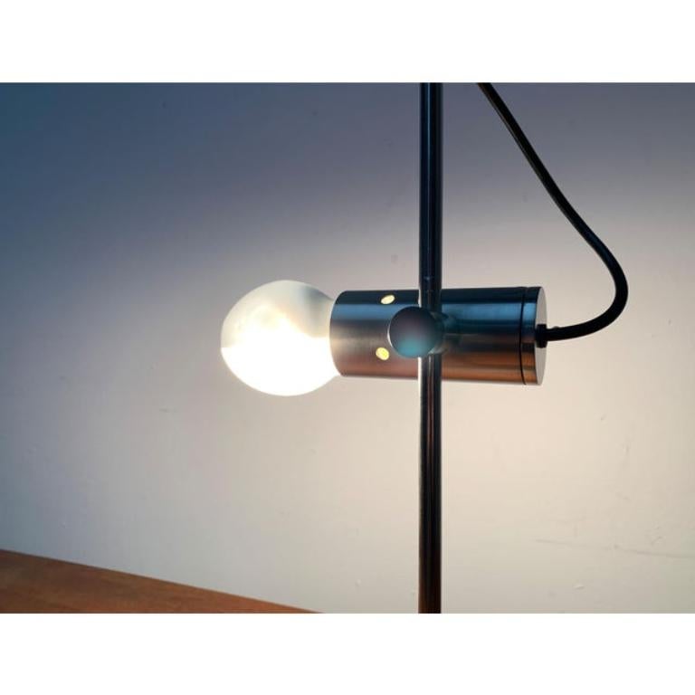 Un raro classico del design di Oluce su disegno di Tito Agnoli degli anni Cinquanta.

Un design minimalista degli anni '50 che era molto in anticipo sui tempi. La testa della luce è costituita da un semplice cilindro di metallo. La parte posteriore