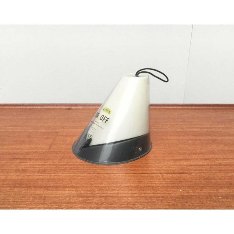 Small table lamp by Luceplan based on a design by Alberto Meda.

This lamp has a very special feature. Tilting the light turns it on or off. On Off is the basis of the design concept here. The lamp body is shaped so that it can be tilted. The light