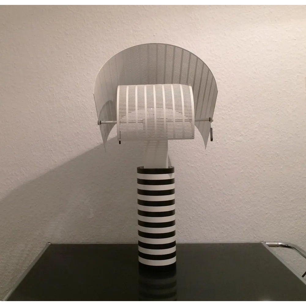 Imposing table lamp by Artemide based on a design by Mario Botta from the 80s.  Postmodernism in its purest form in color and materiality. A timeless design classic that easily fits into other design eras. This lamp stands out as a solitaire and is