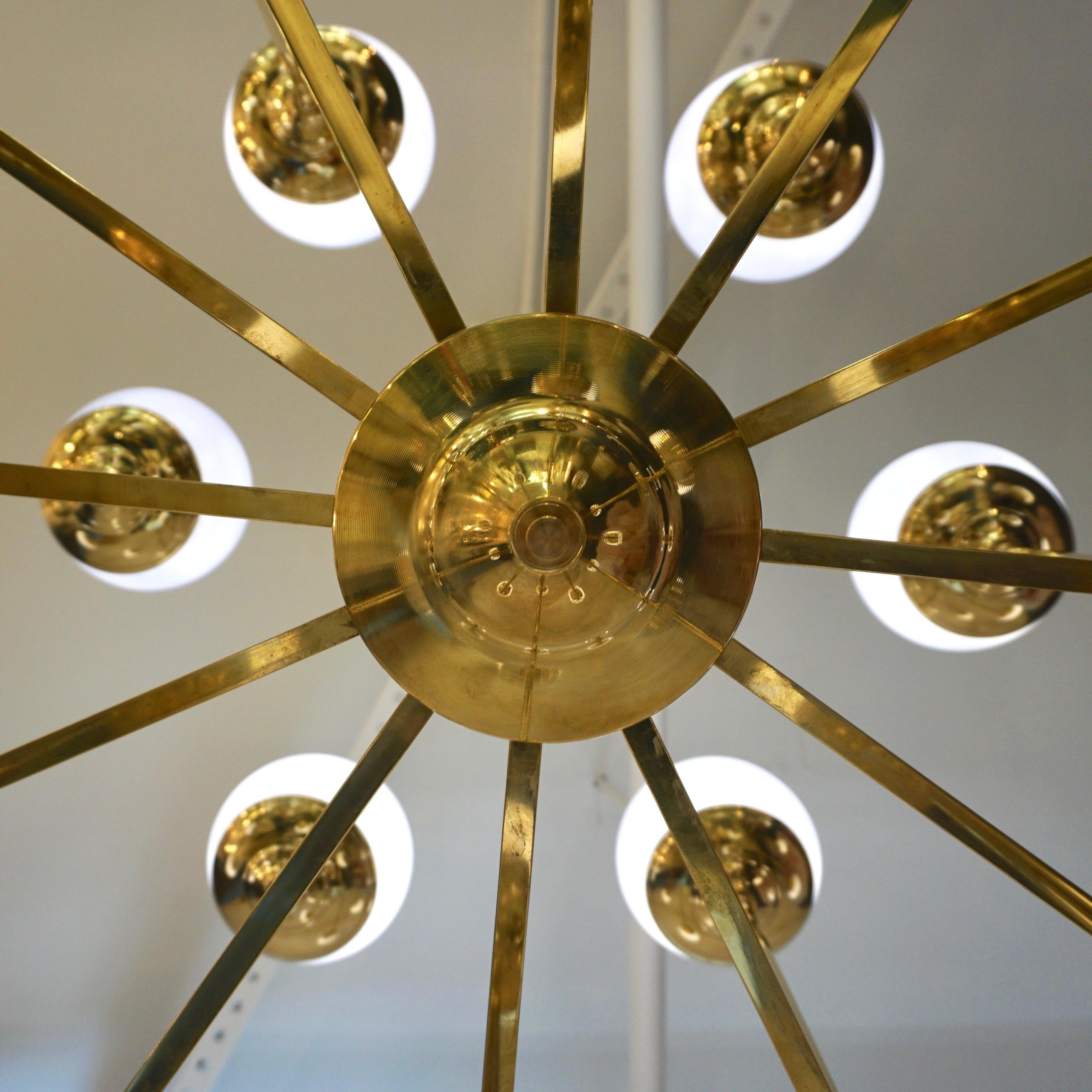 Lustre circulaire contemporain sur mesure au design géométrique minimaliste d'inspiration Sputnik Modern du milieu du siècle dernier, entièrement fabriqué à la main en Italie. La structure en laiton est décorée de 24 globes en verre soufflé de