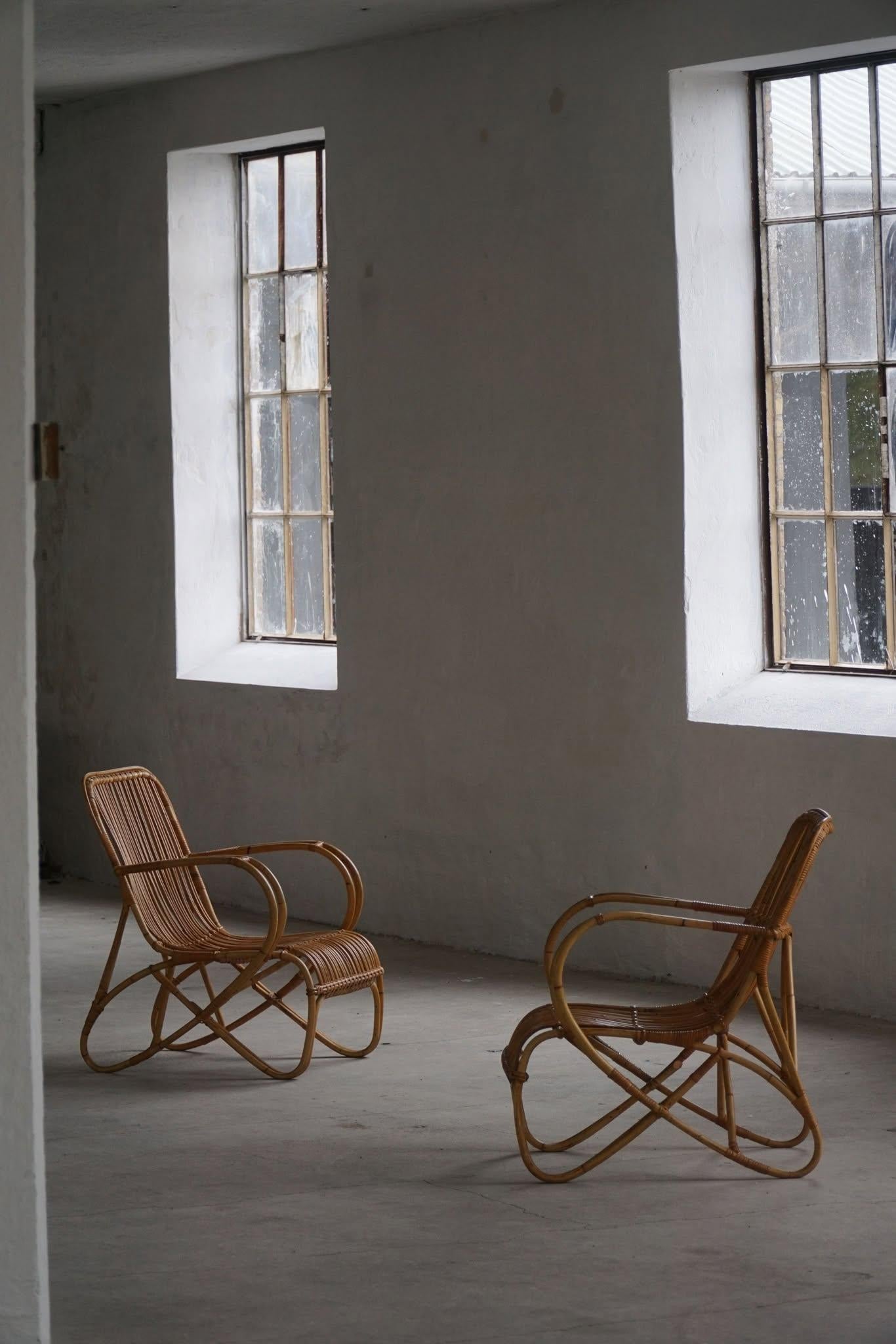 Este elegante par de sillones de bambú de la Modernidad de Mediados de Siglo, fabricados en Italia en la década de 1960, presentan armazones orgánicos graciosamente curvados que resaltan la belleza natural del material. El diseño es ligero y robusto
