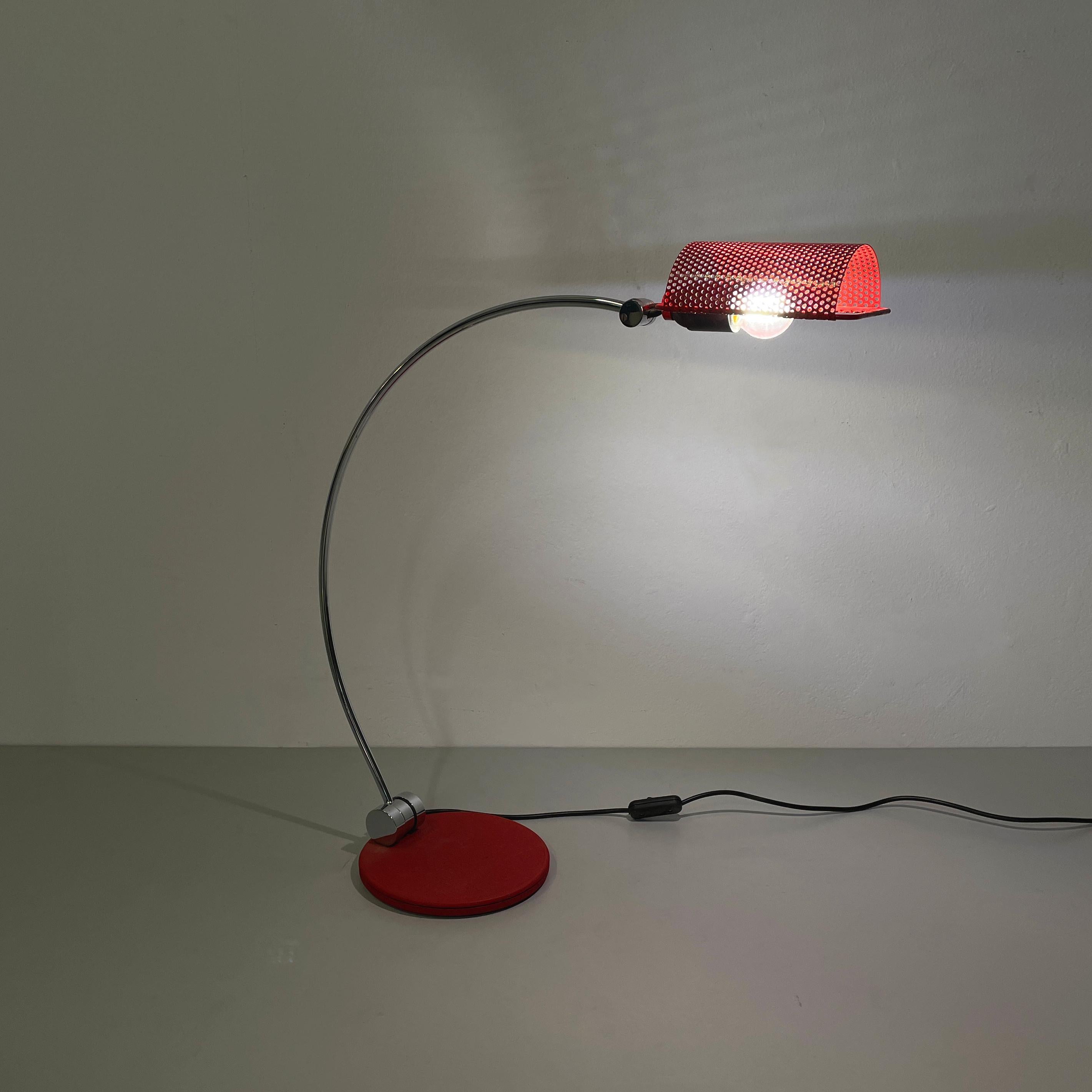 Italian modern Adjustable table lamp in red metal  sheet and steel rod, 1980s
Table lamp with round base in red painted metal. The diffuser is made of a curved and perforated sheet of red painted metal. The steel rod structure allows, through a pin