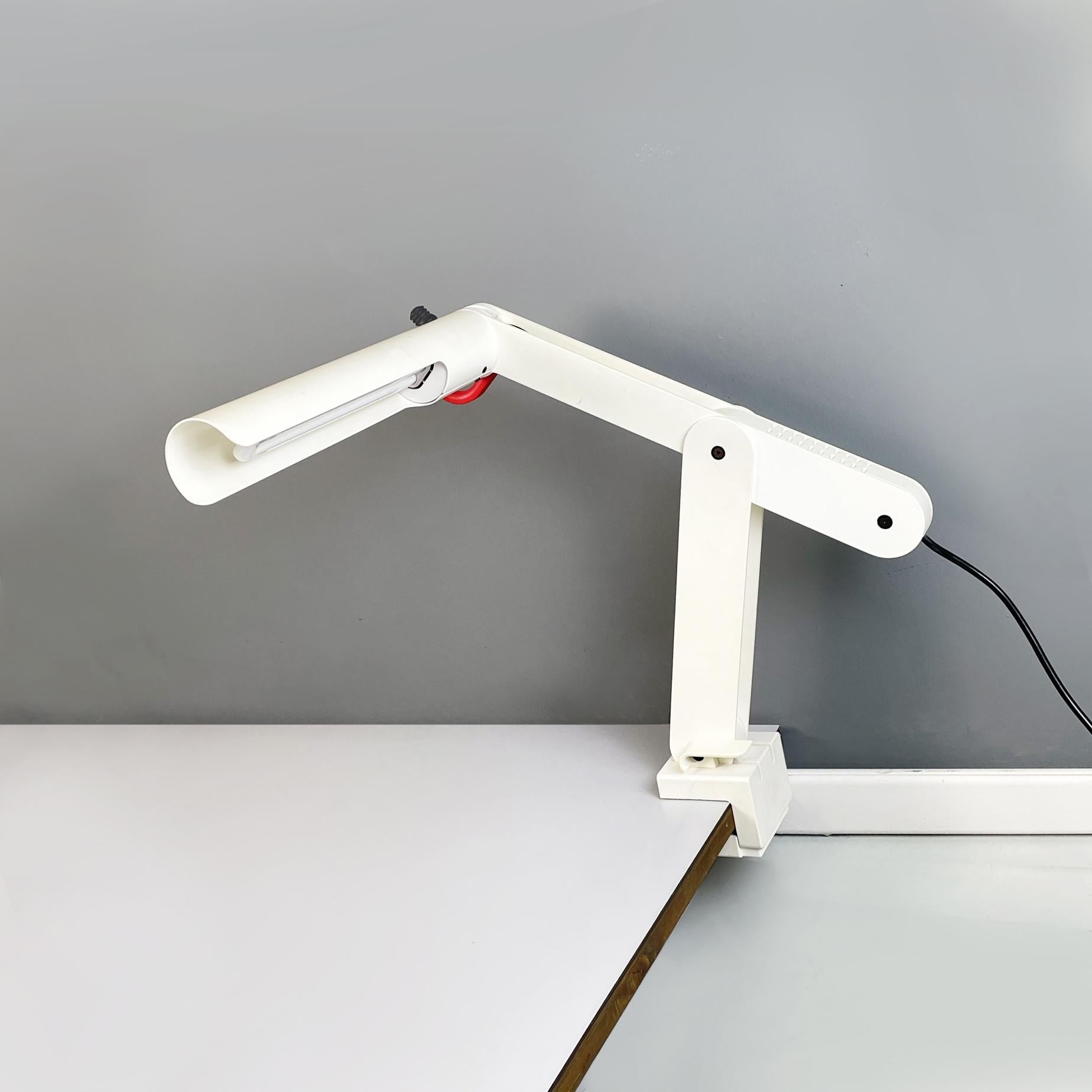 Italian modern Adjustable white metal table lamp with clamp, 1980s
Adjustable metal table lamp. The cylindrical diffuser is in white metal with a red plastic handle. The lamp has one arm with a free body and the other movable through a knob. At the