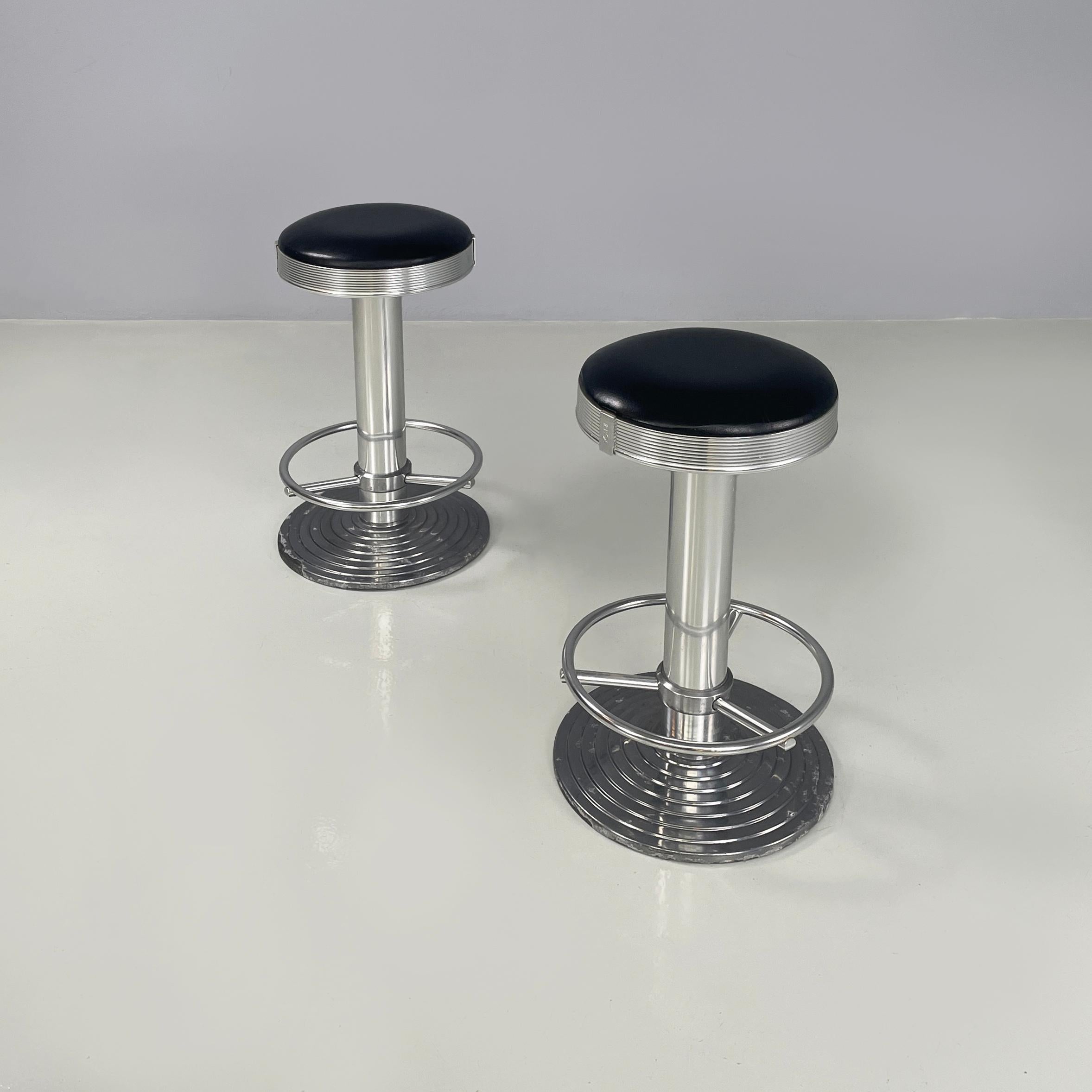 Italian Modern Aluminum and black leather bar stools Billy by Ycami, 1990s
Pair of bar stools mod. Billy with round seat padded and covered in black leather, with grooved aluminum profile. The structure is entirely made of aluminium. At the base
