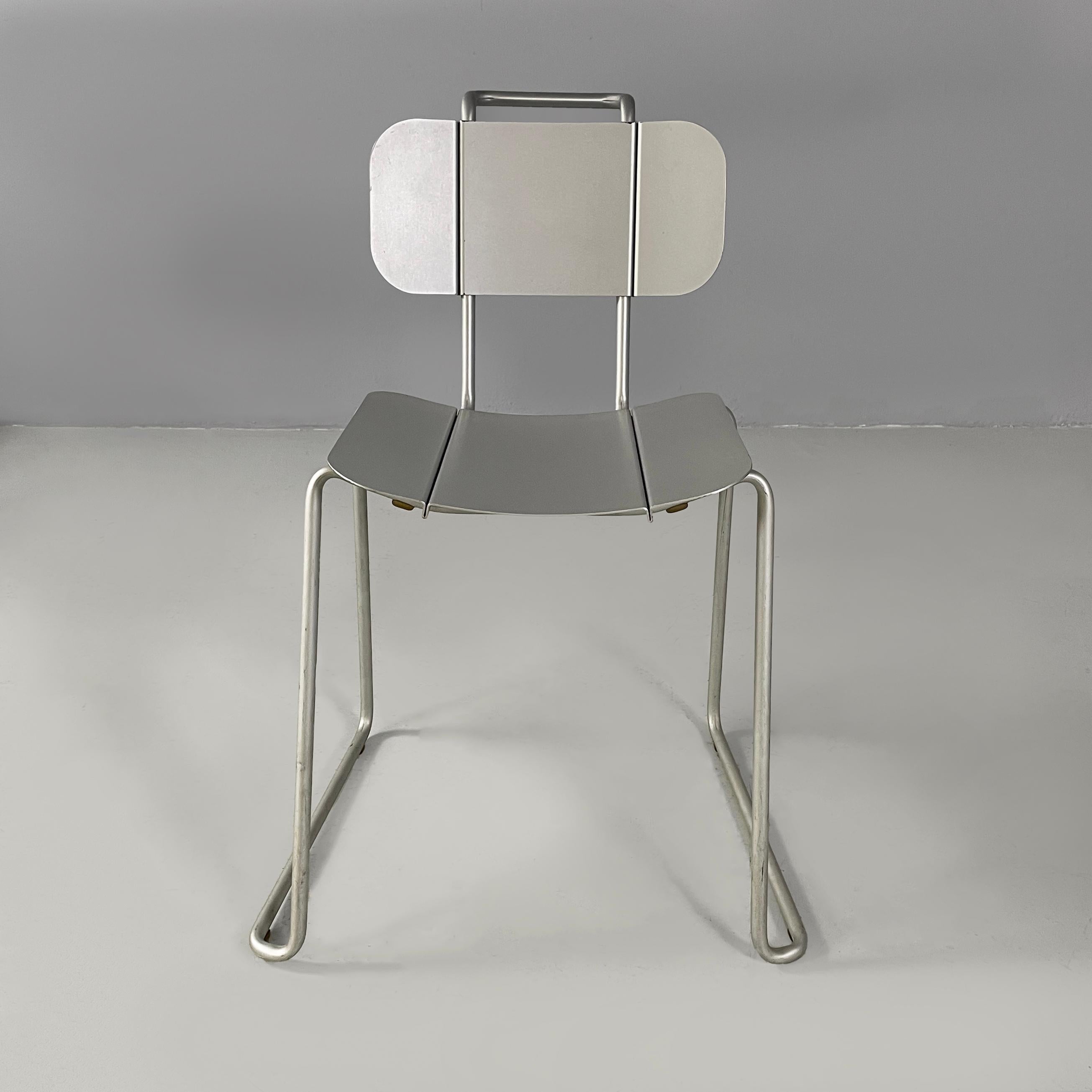 Italian modern aluminum chairs by Tanzi, 1980s
Set of four chairs with rectangular base, entirely in aluminum. The seat and back are rectangular with rounded corners and have two “folds” that act as decoration. The metal rod structure is composed of