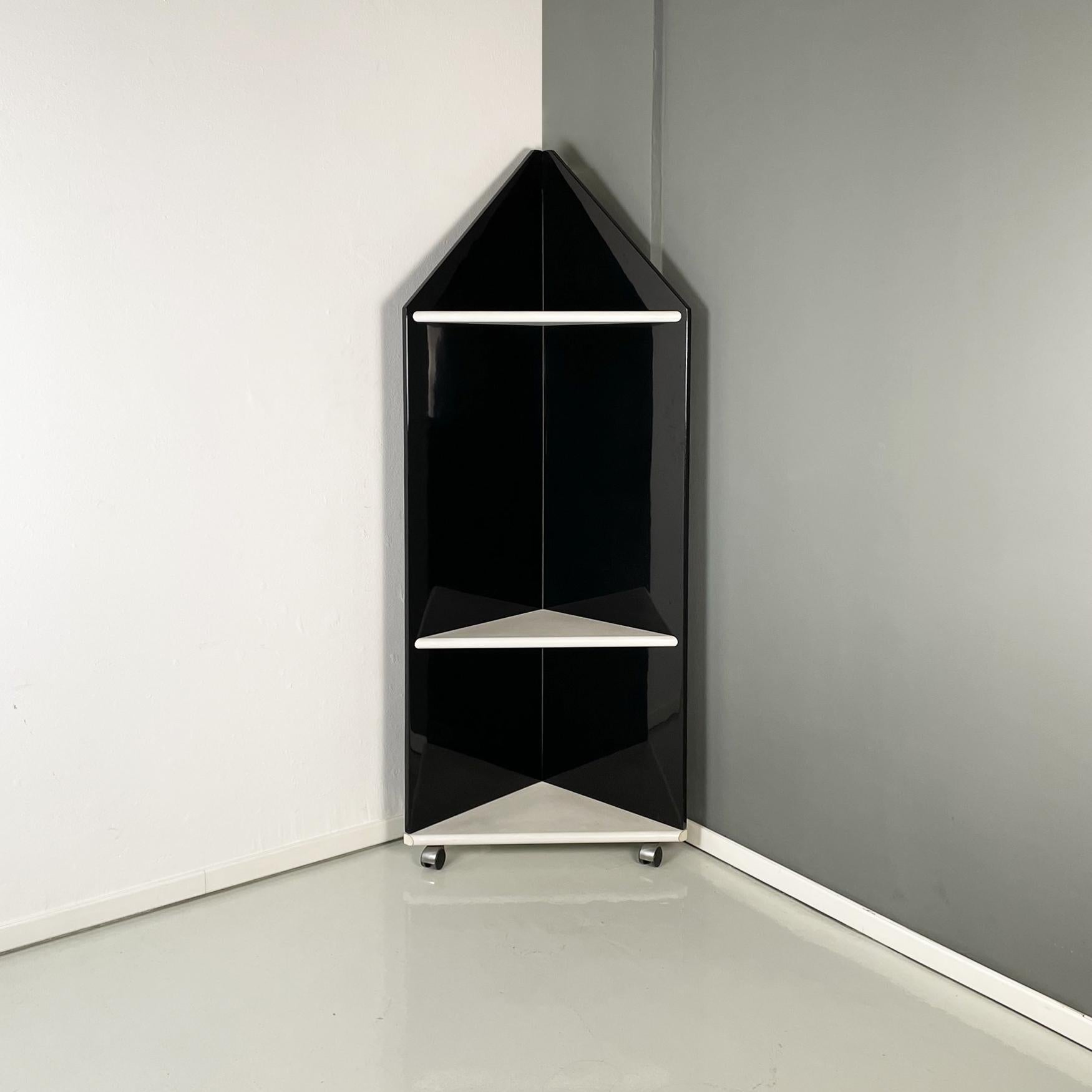 Italian modern Angular bookcase in black lacquered and white wood, 1980s
Elegant and fantastic angular bookcase with triangular base in black lacquered wood. It has 3 triangular shelves in white painted wood. This bookcase has at the base 3 wheels.