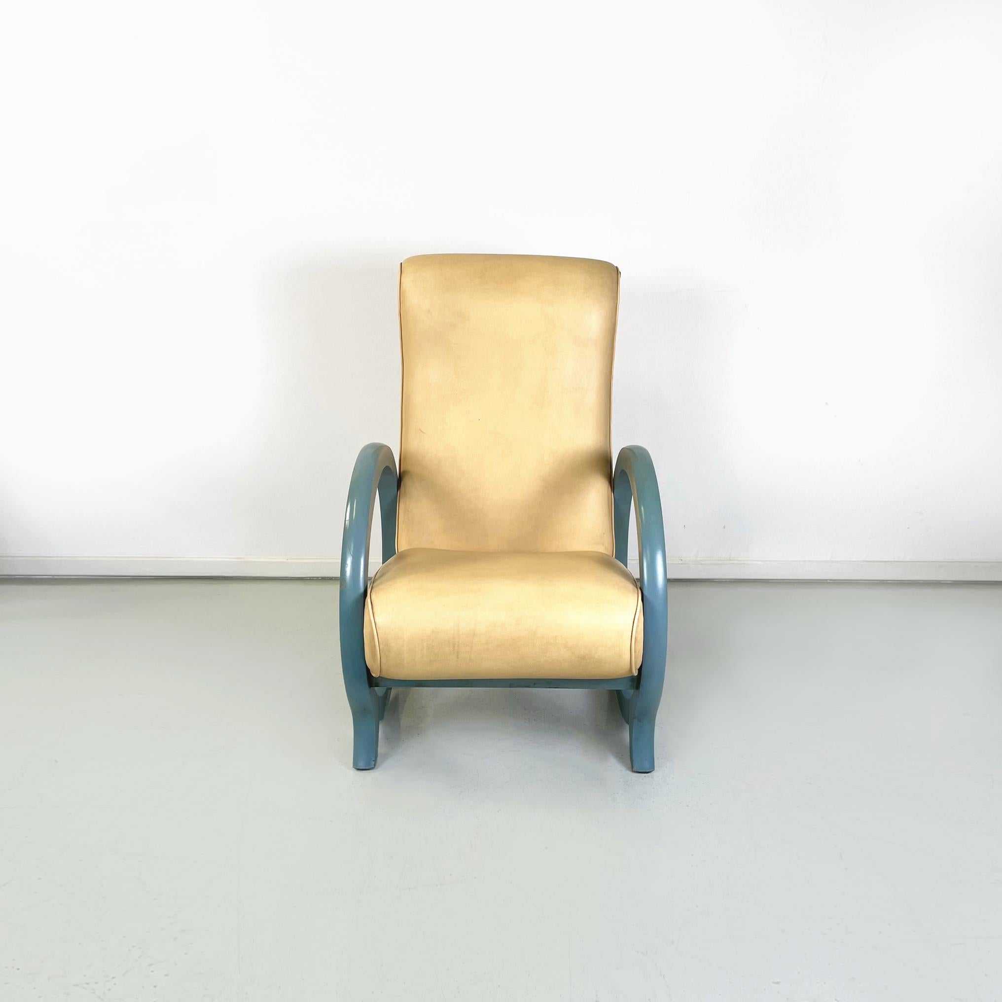 Italian modern Armchair in beige leather and light blue wood, 1980s
Armchair with rounded seat and back, padded and upholstered in beige leather. The cerulean light blue painted wooden armrests are in the shape of a circle, at the base of which