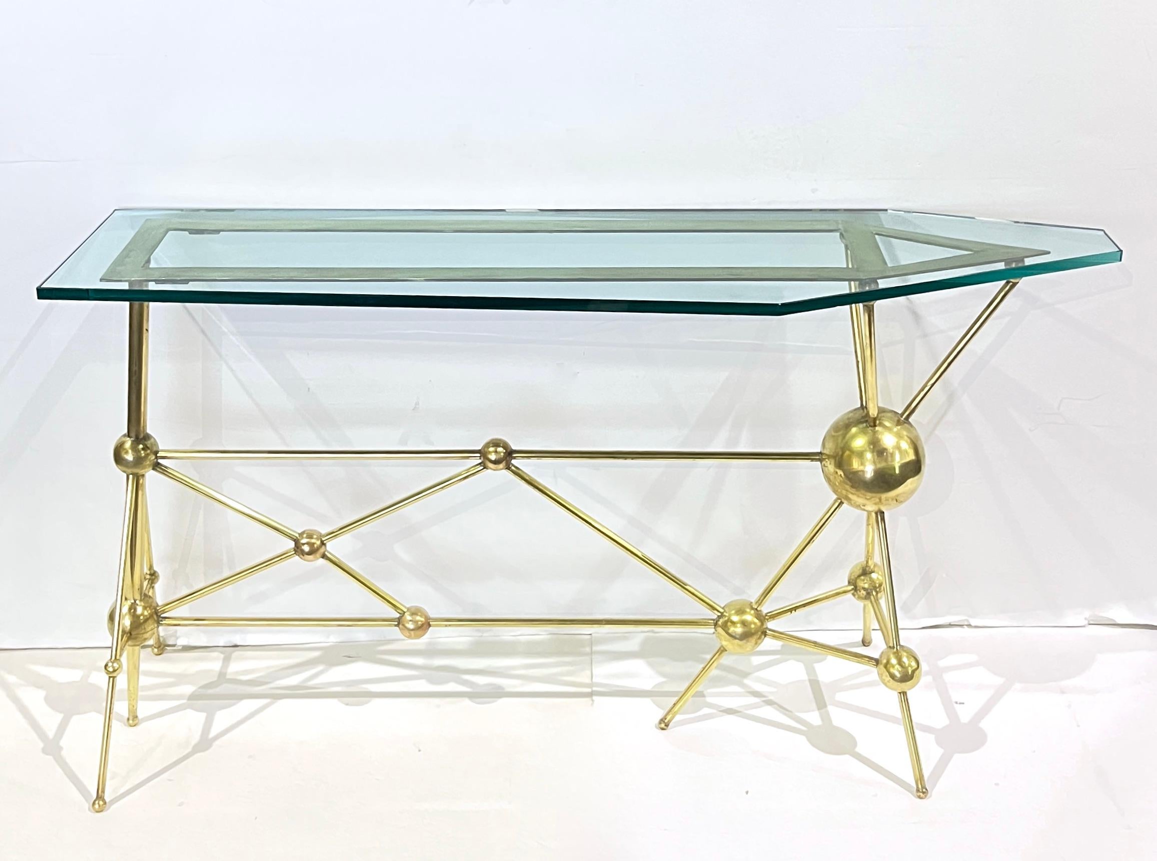 Early 21st century slim design, an atomic console entirely hand-crafted in Italy, ensuring uniqueness and artisanal quality. The base is hand sculpted from polished brass, featuring a geometric web of rods intersecting through a stunning arrangement