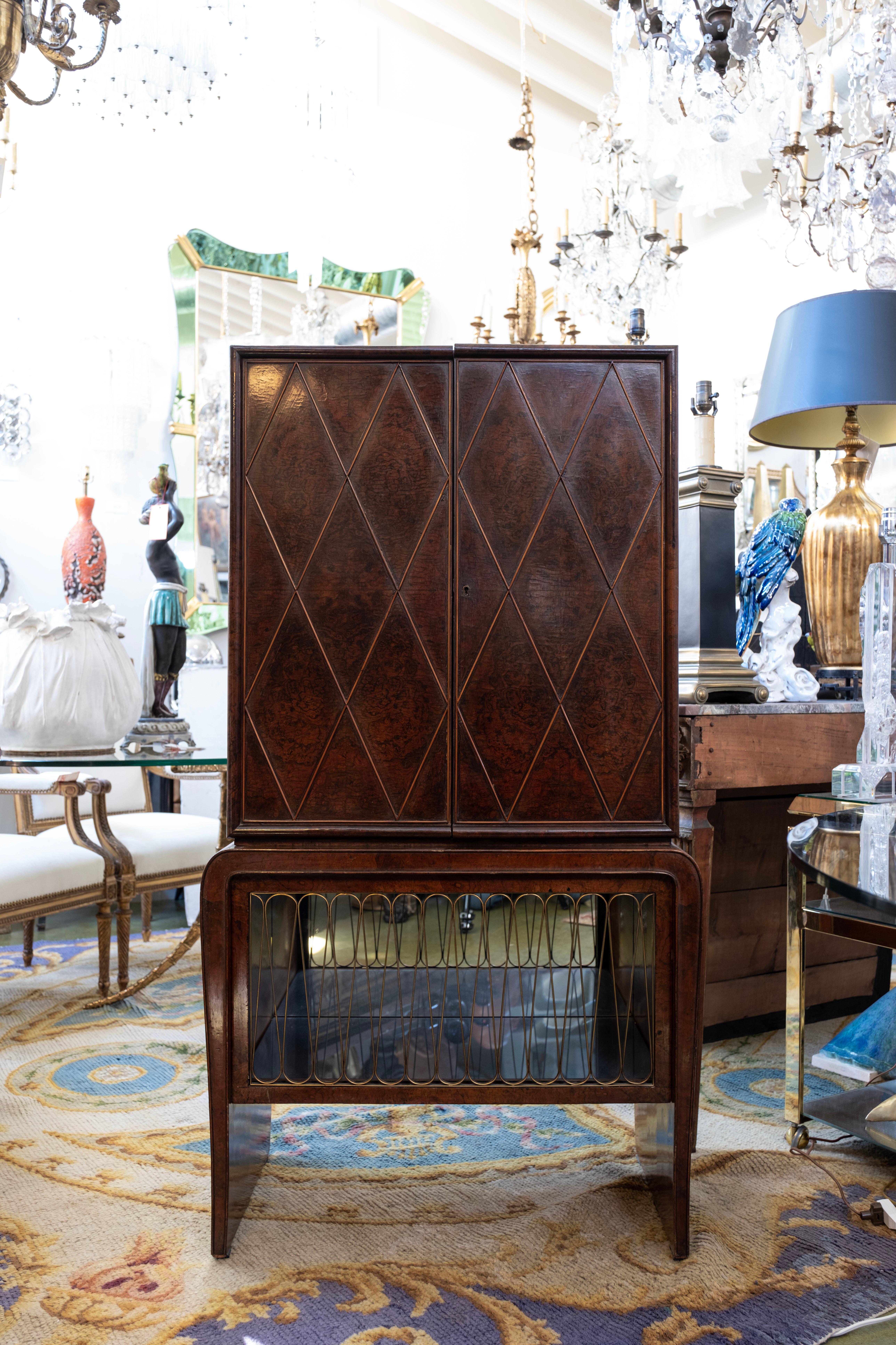 Italian Modern bar cabinet attributed to Gio Ponti. 
This stunning superior Italian burlwood quality dry bar cabinet or vitrine has an interesting quilted design across the front top portion with divided areas for 
bottles and glasses with unusual