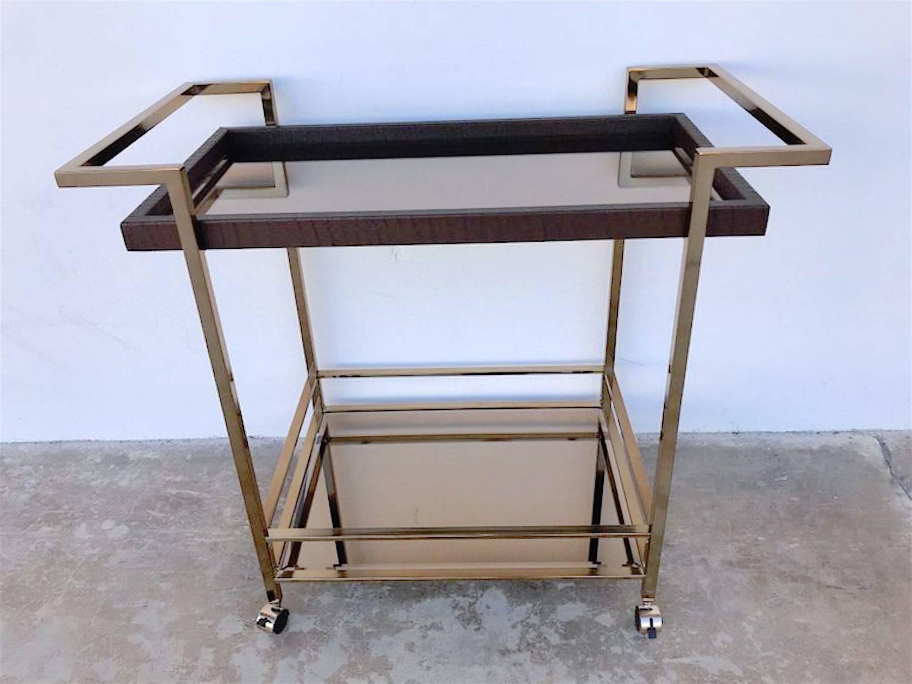 Italian modern gilt metal and leather bar cart, sleek and stylish with two stationary handles, the upper tier measure: 30