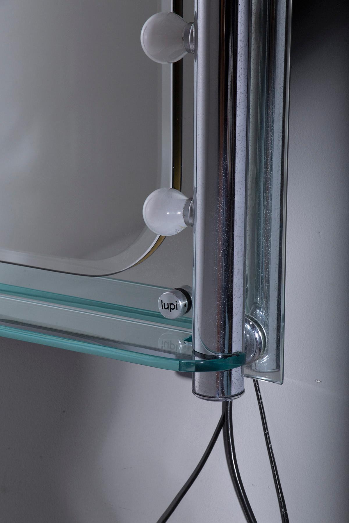 This Italian modern bathroom mirror, designed by the renowned brand LUPI in the 1970s, is a beautifully crafted piece that embodies the elegance and innovation of mid-century modernist design. The mirror is distinguished by several key features that