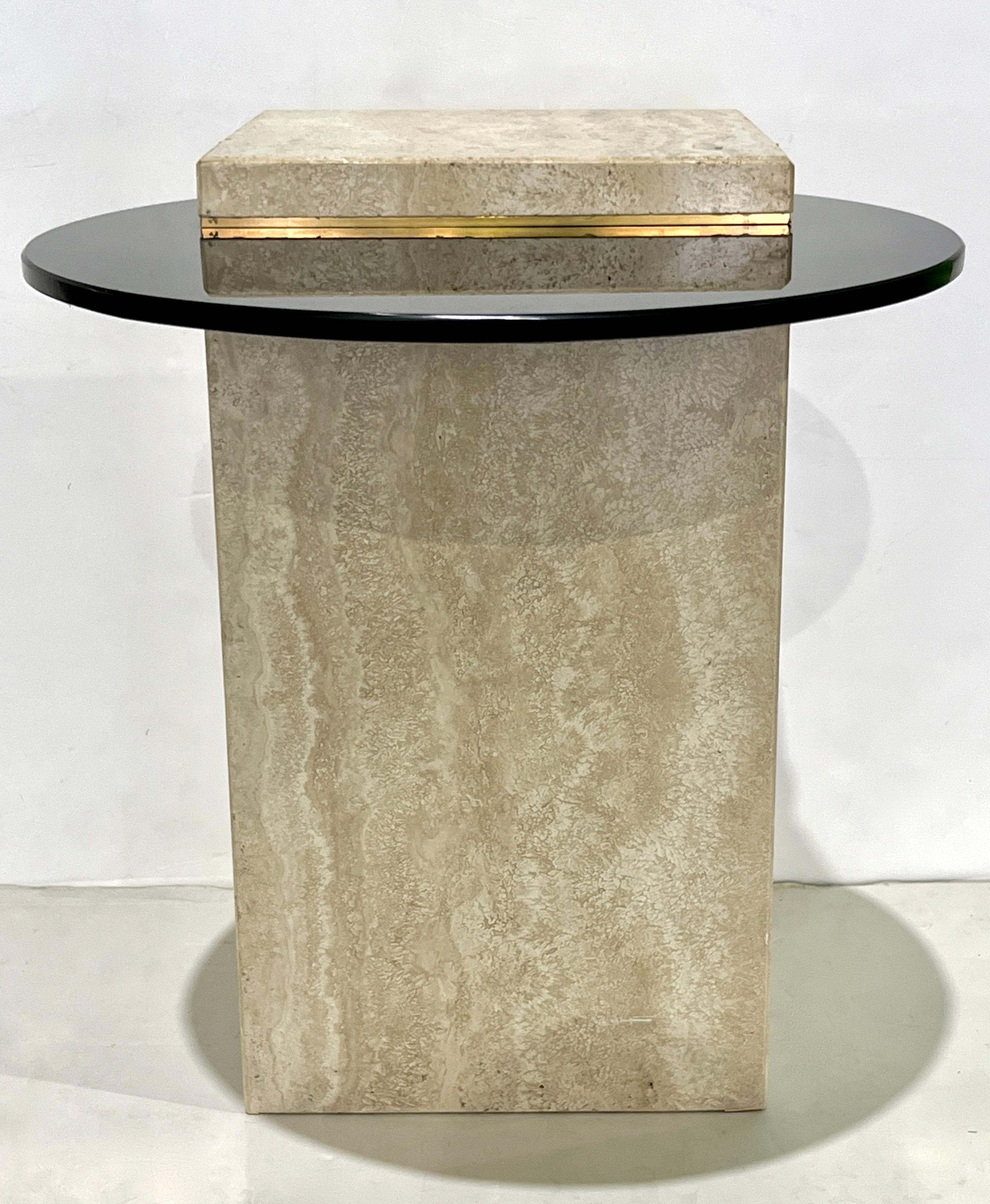 Elegante mesa auxiliar posmoderna con una sólida base rectangular de mármol travertino crema marfil combinada con una llamativa tapa redonda de cristal biselado ahumado. El cristal templado de 1/2 pulgada está perfilado por detalles de latón,