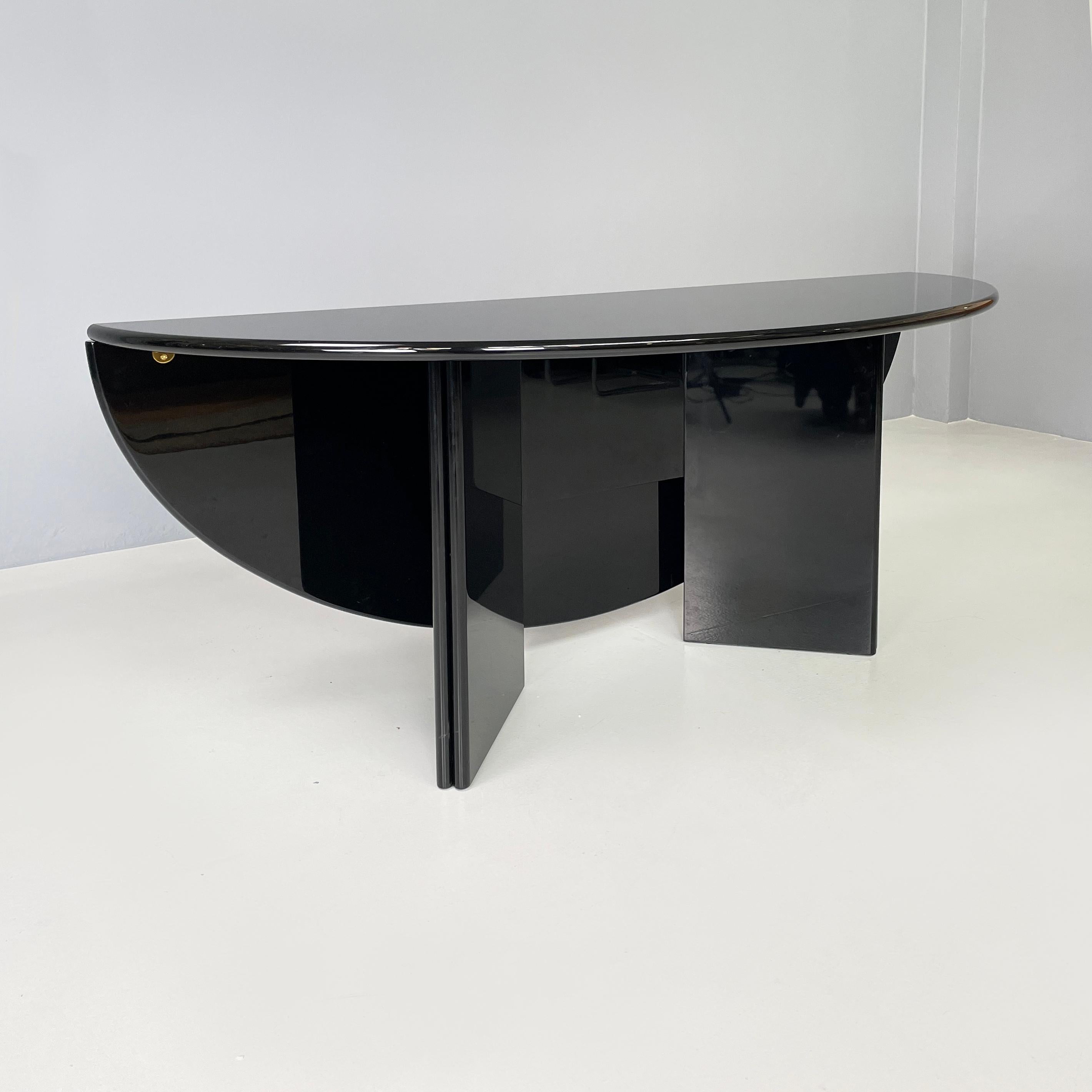Italian modern Black Dining table or console by Kazuhide  Takahama for Cassina, 1970s
Dining table or console mod. Antella in black lacquered wood. The particularity of the top which can be halved from oval through golden metal hinges, becoming