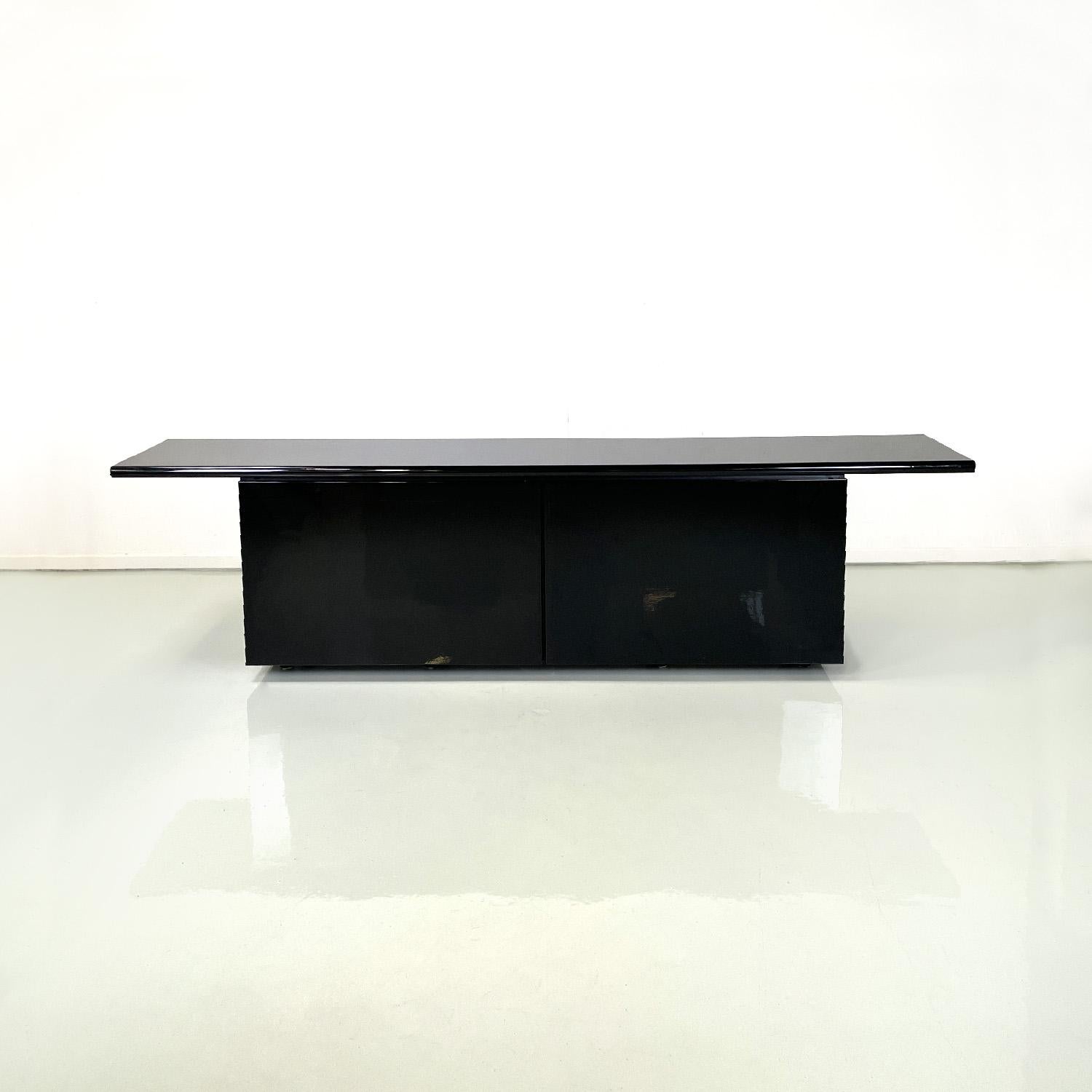 Italian modern black sideboard Sheraton by Stoppino and Acerbis for Acerbis 1977
Sideboard mod. Sheraton in glossy black lacquered wood. The rectangular top has a beveled front edge. On the front it has three compartments with glass shelves, the two
