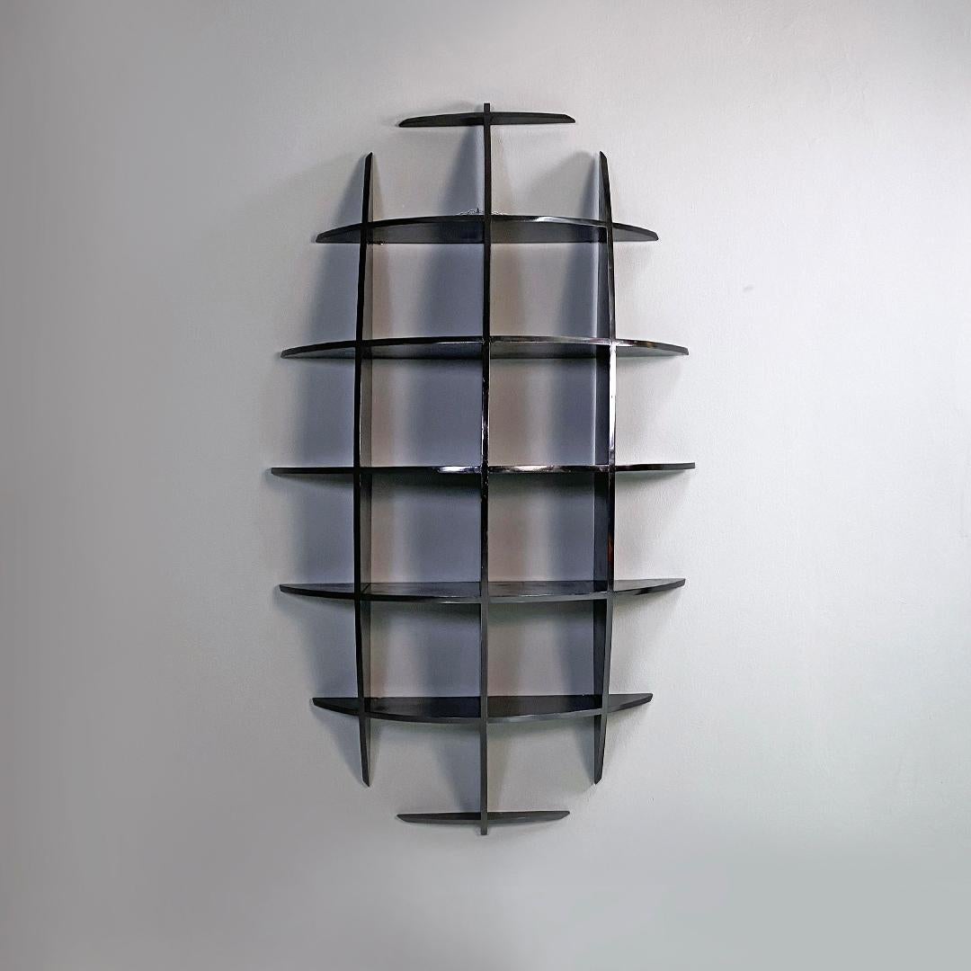 Italian modern black wood convex shape wall bookcase in the style of Joe Colombo 1980s.
Bookcase in black wood, composed of 3 long vertical shelves and 7 horizontal shelves crossed between them to form numerous shelves. The convex shape is given by